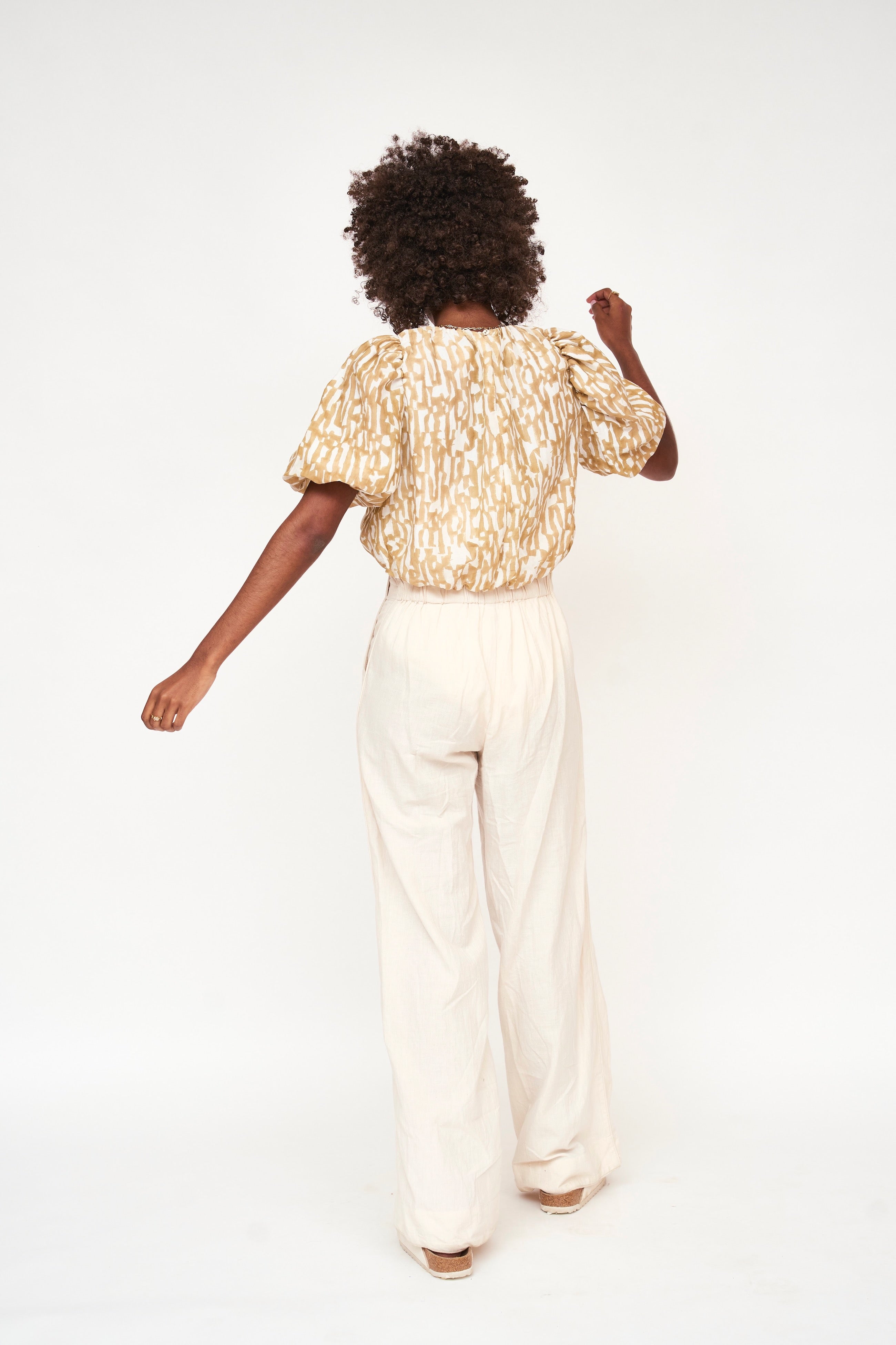 Girl wearing MIRTH women's ballon sleeve andaman cropped top in brown driftwood cotton silk