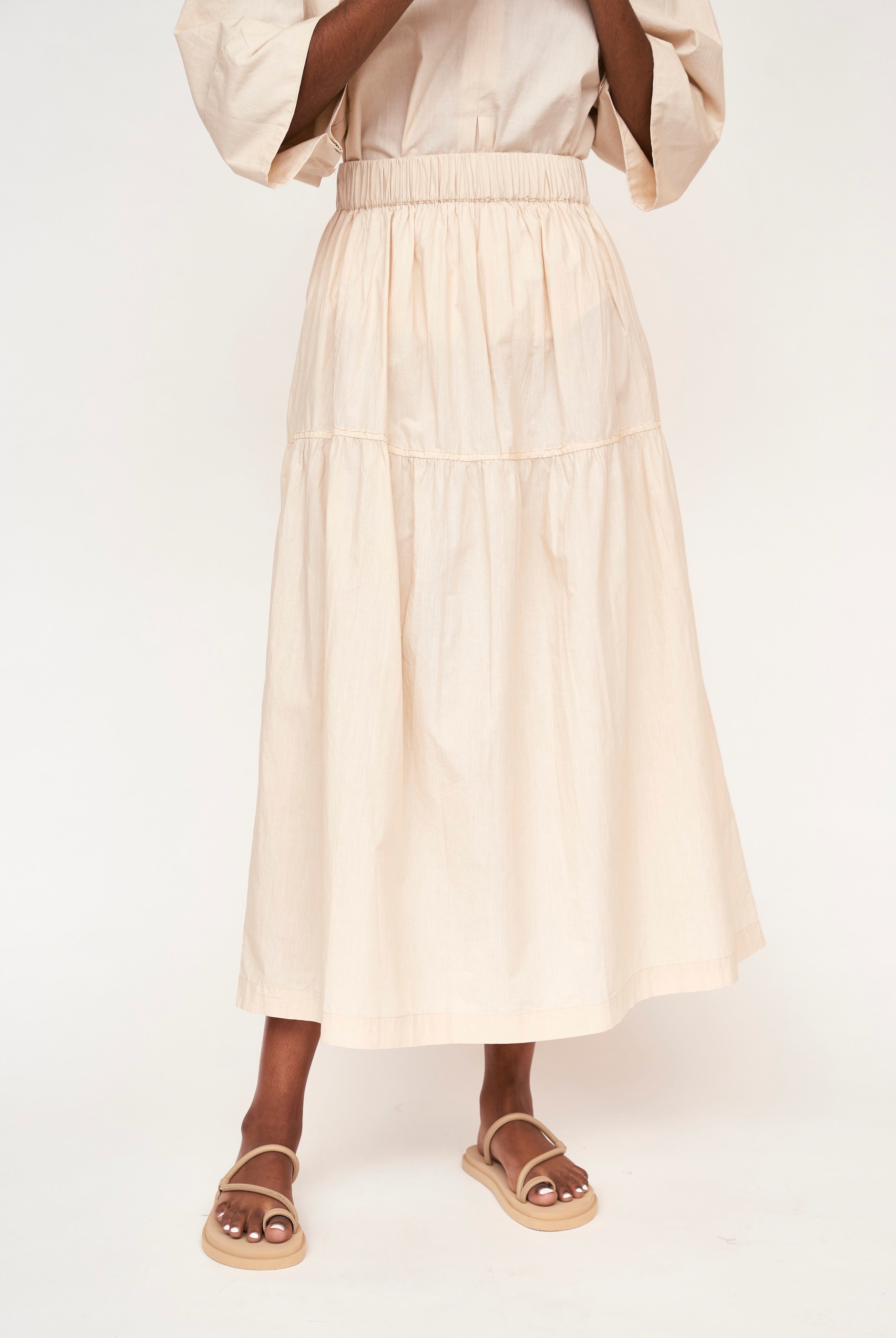 Girl wearing MIRTH women's elastic waist tiered brighton long skirt in parchment cream cotton poplin