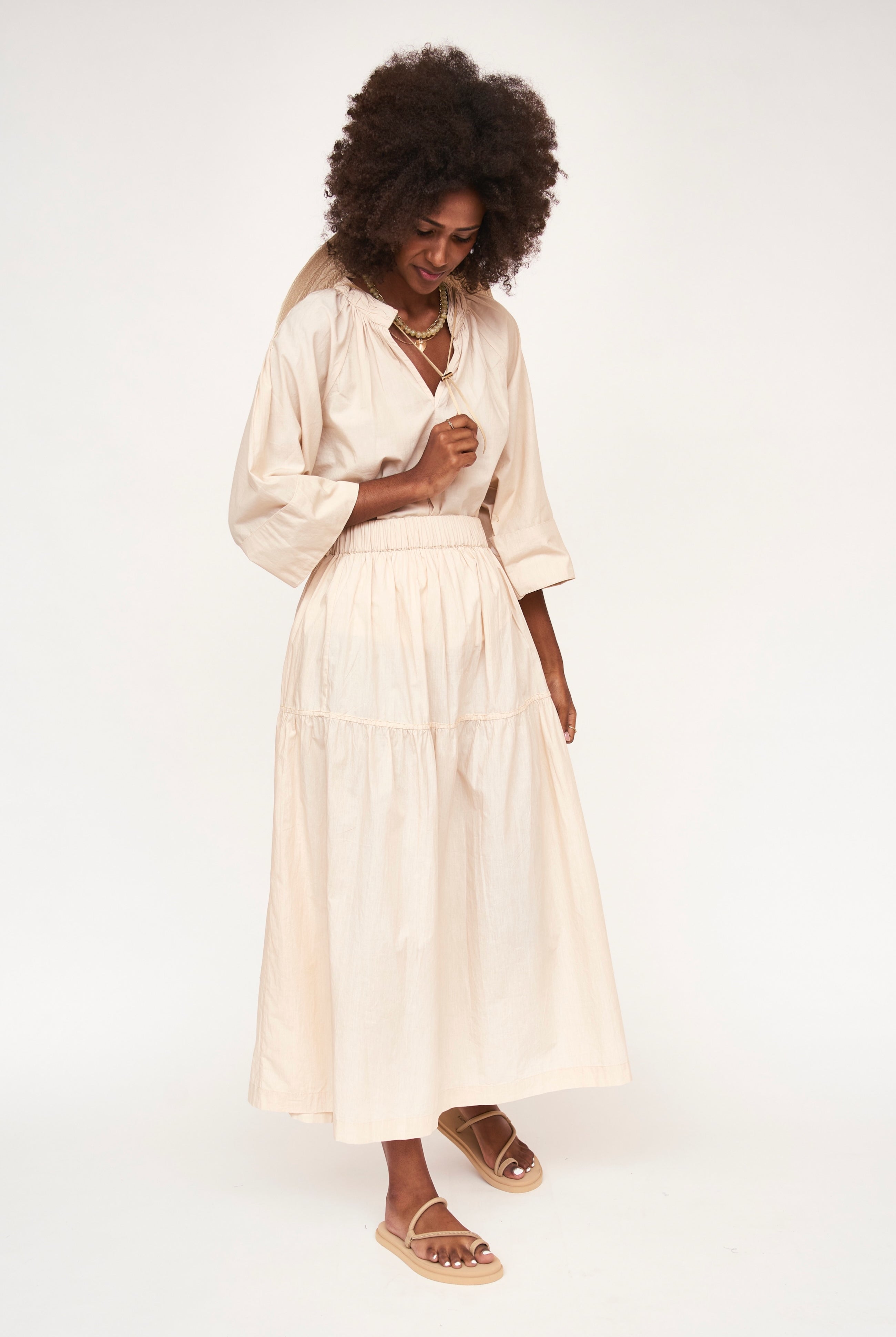 Girl wearing MIRTH women's elastic waist tiered brighton long skirt in parchment cream cotton poplin