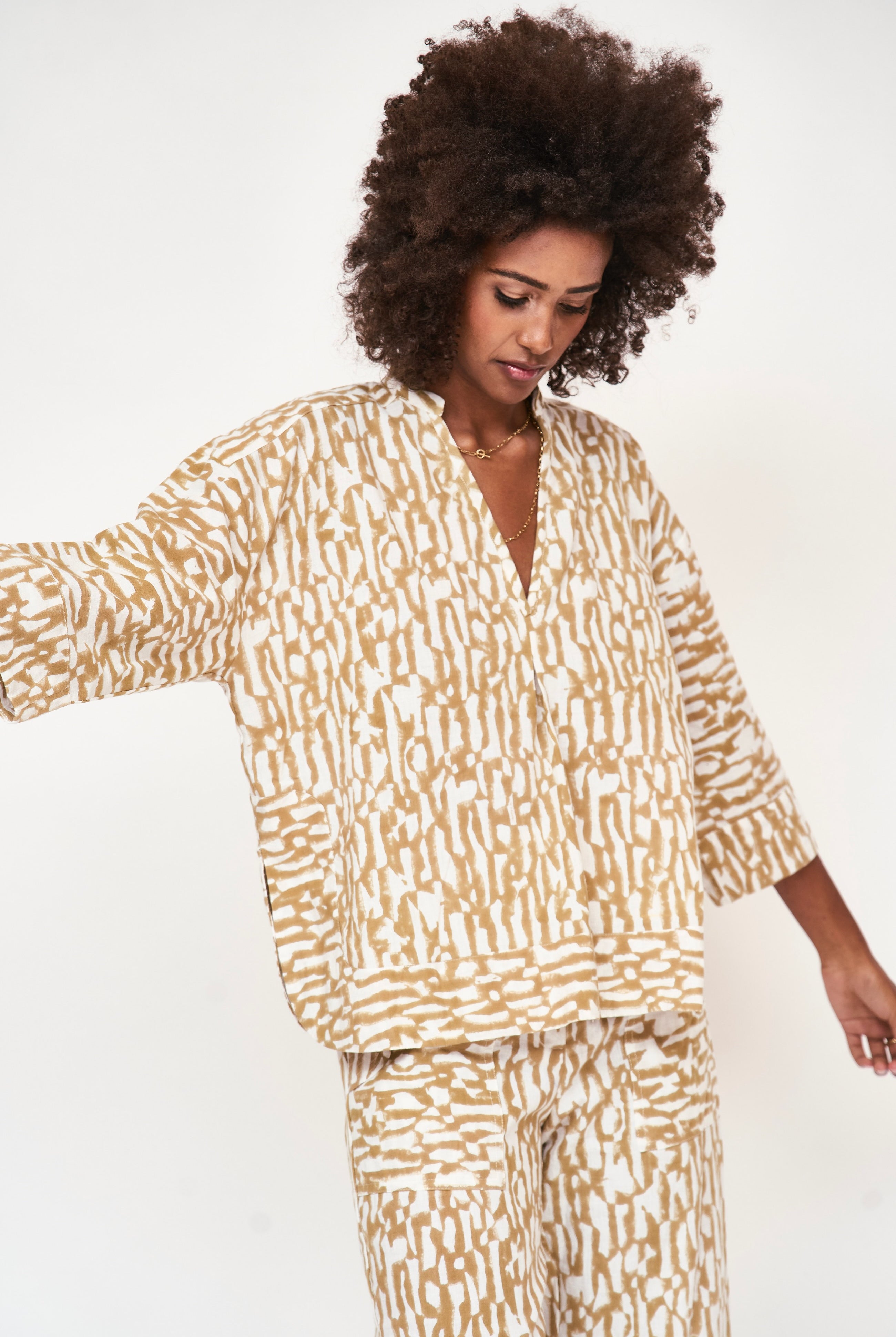 Girl wearing MIRTH women's v neck three quarter sleeve camden top in driftwood brown print cotton