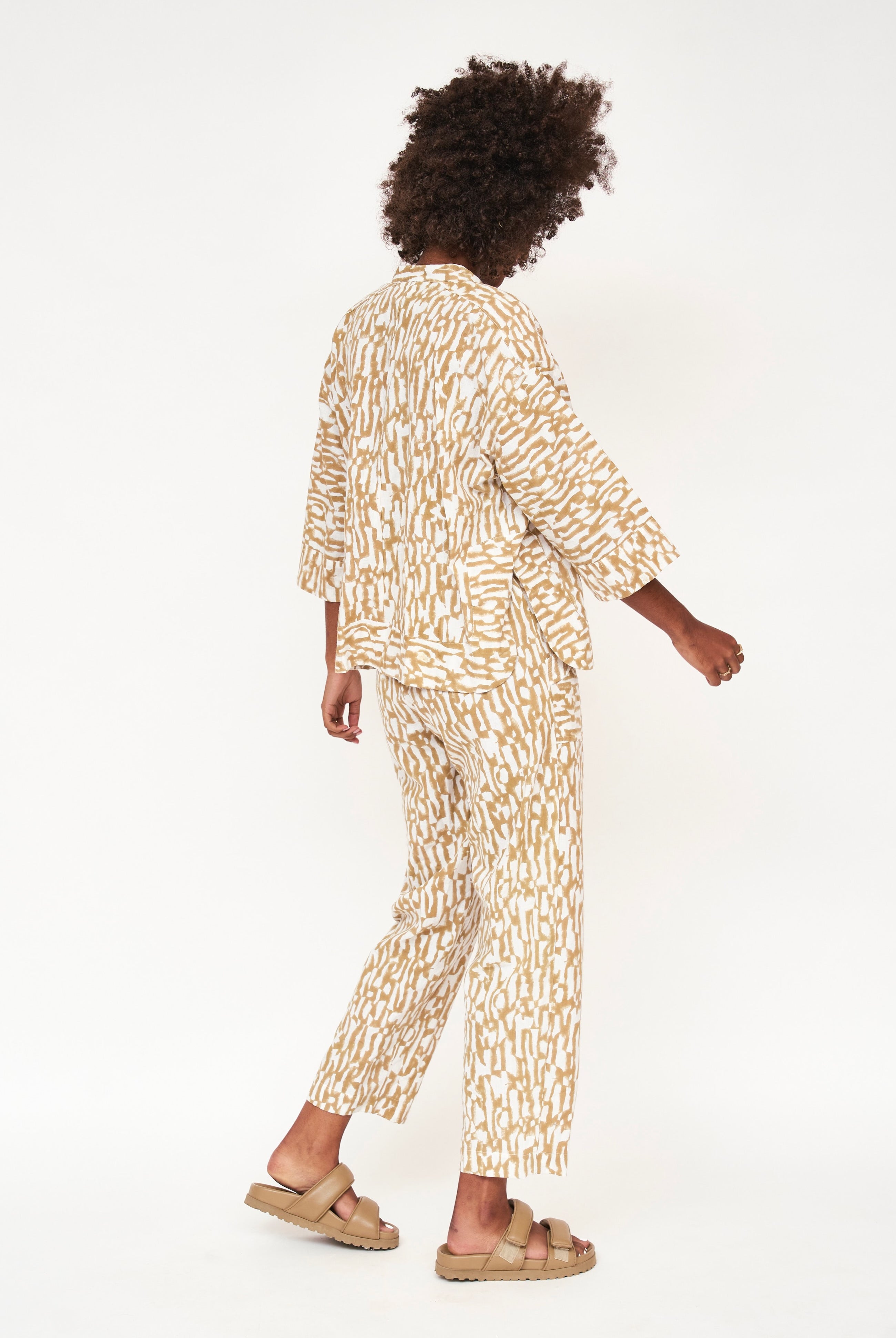 Girl wearing MIRTH women's v neck three quarter sleeve camden top in driftwood brown print cotton