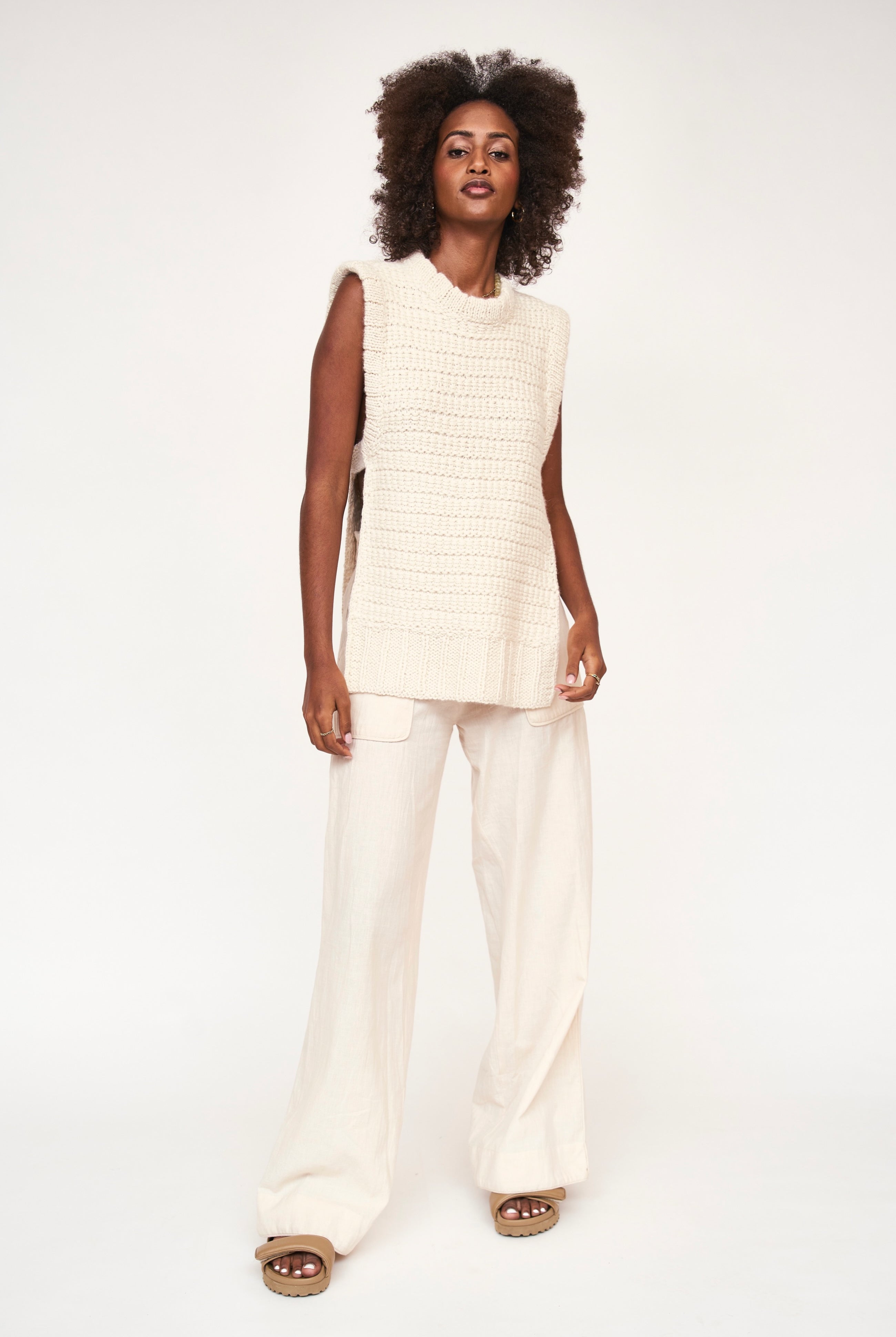 Girl wearing MIRTH women's sleeveless carmel open side knit sweater vest in snow white alpaca wool