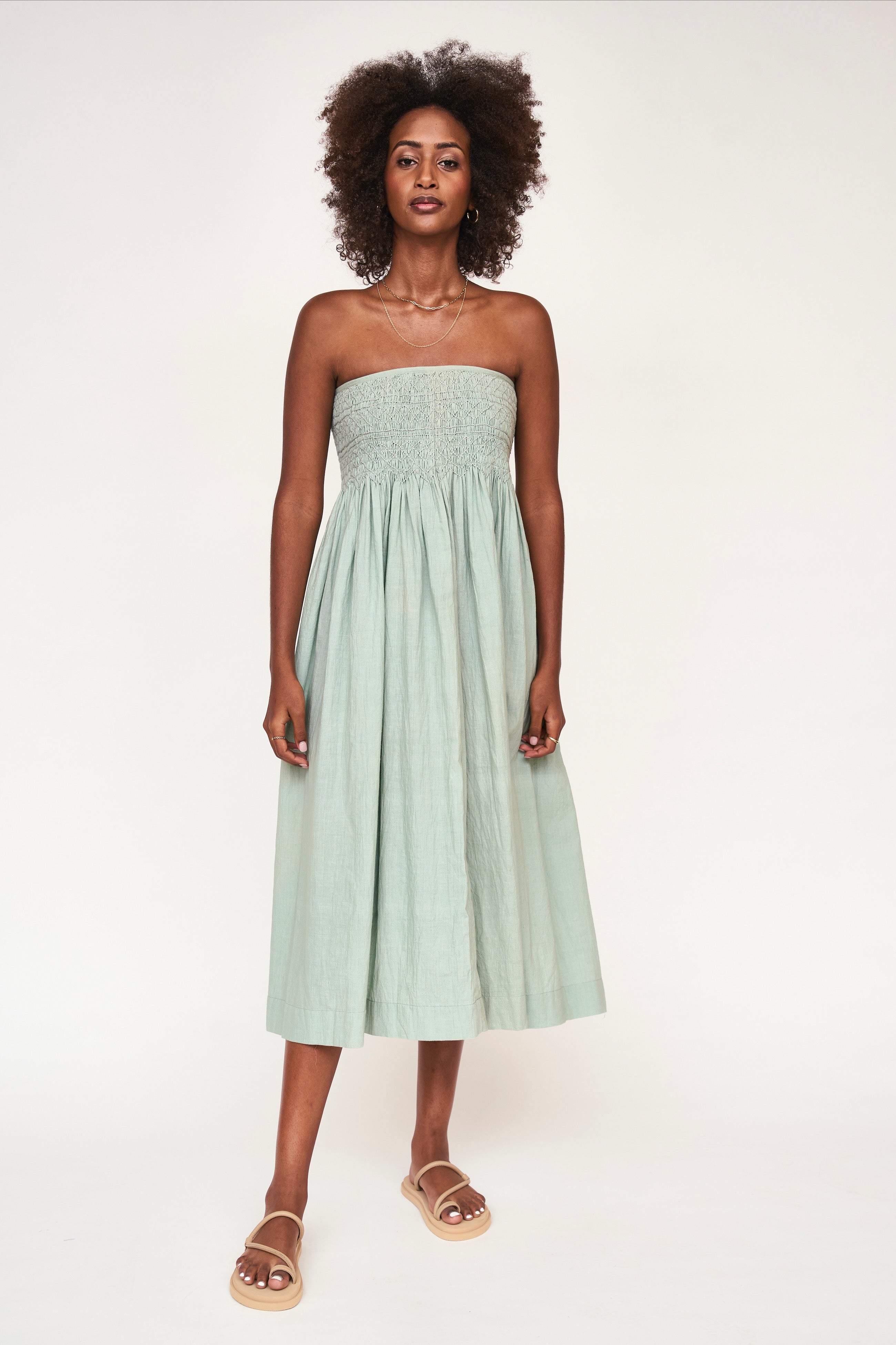 Girl wearing MIRTH women's smocked elastic sleeveless georgia midi dress in frost blue cotton