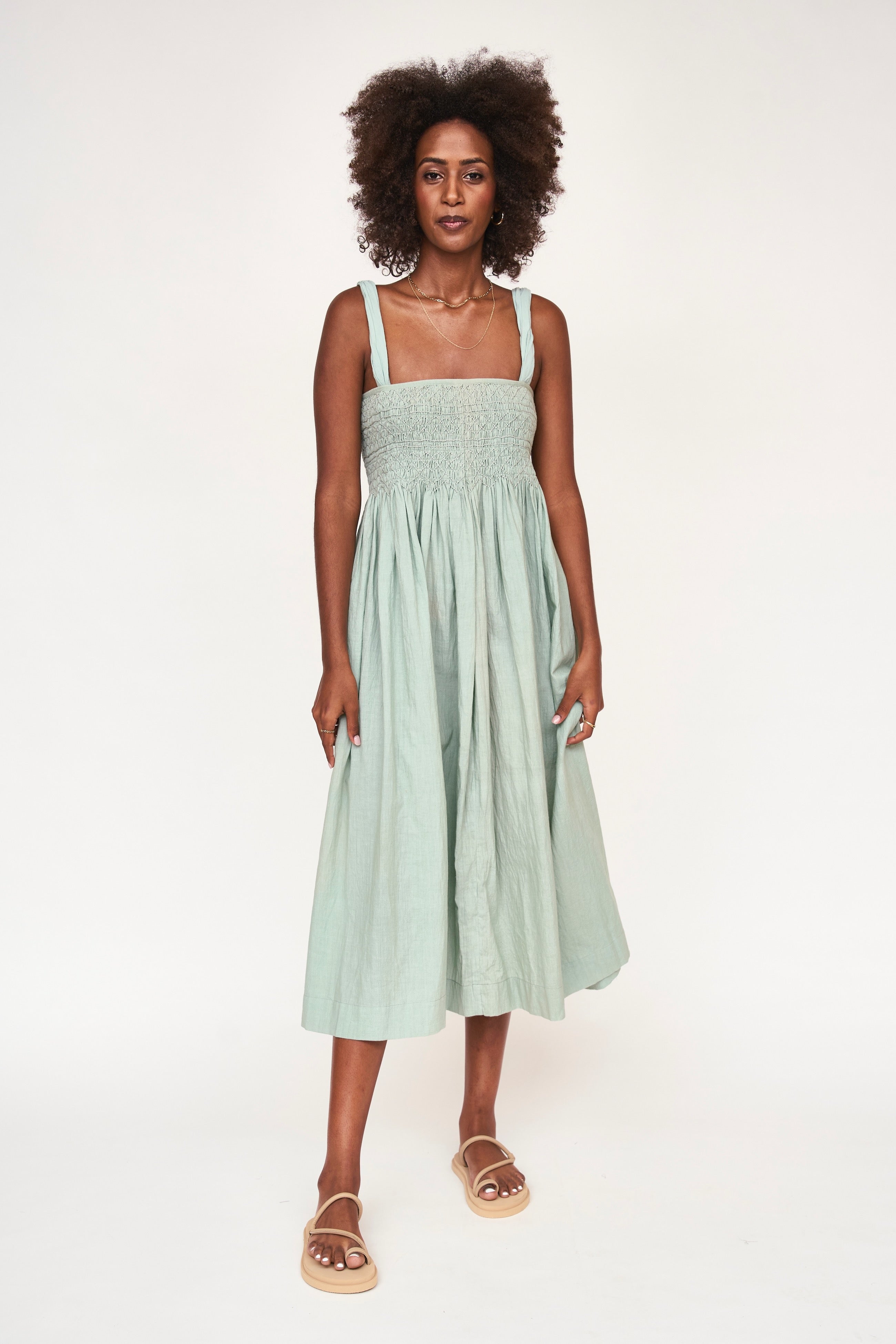 Girl wearing MIRTH women's smocked elastic sleeveless georgia midi dress in frost blue cotton