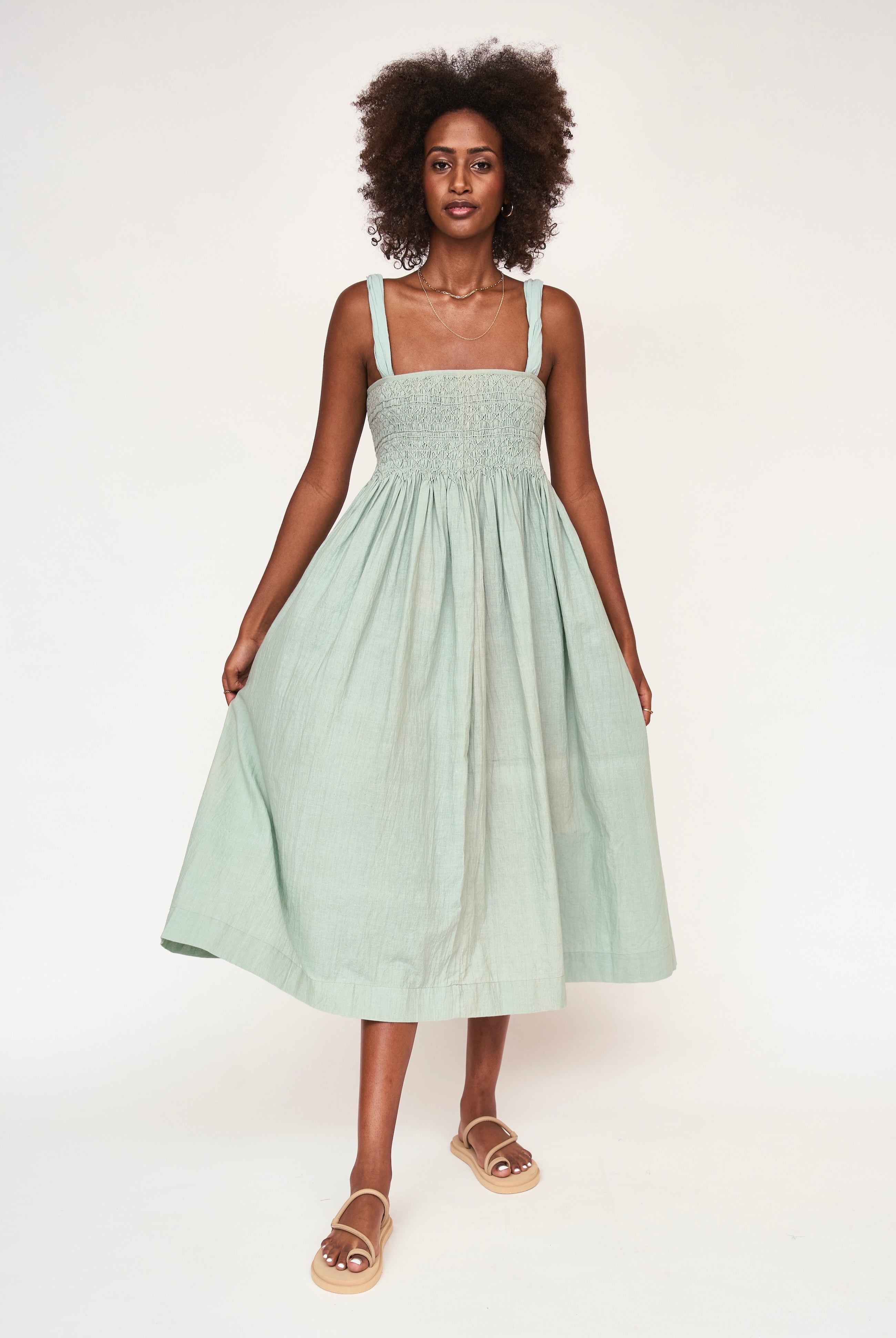 Girl wearing MIRTH women's smocked elastic sleeveless georgia midi dress in frost blue cotton