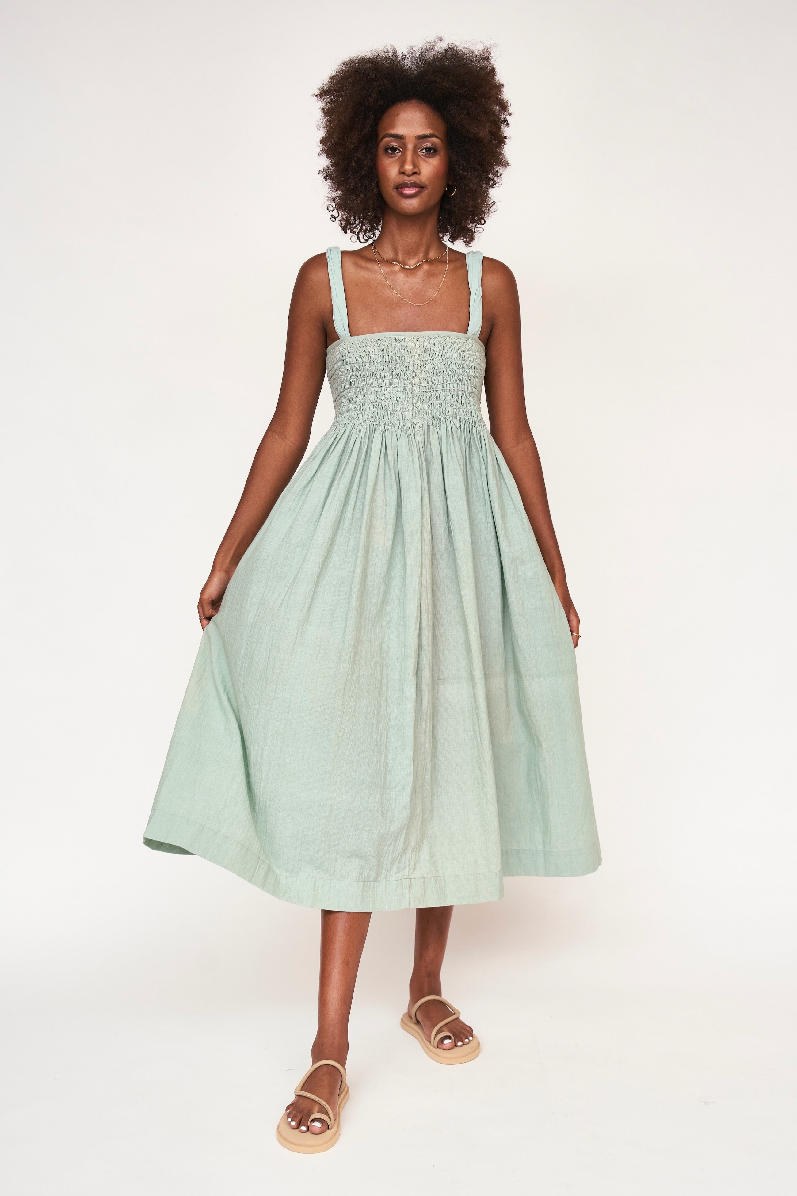 Girl wearing MIRTH women's smocked elastic sleeveless georgia midi dress in frost blue cotton