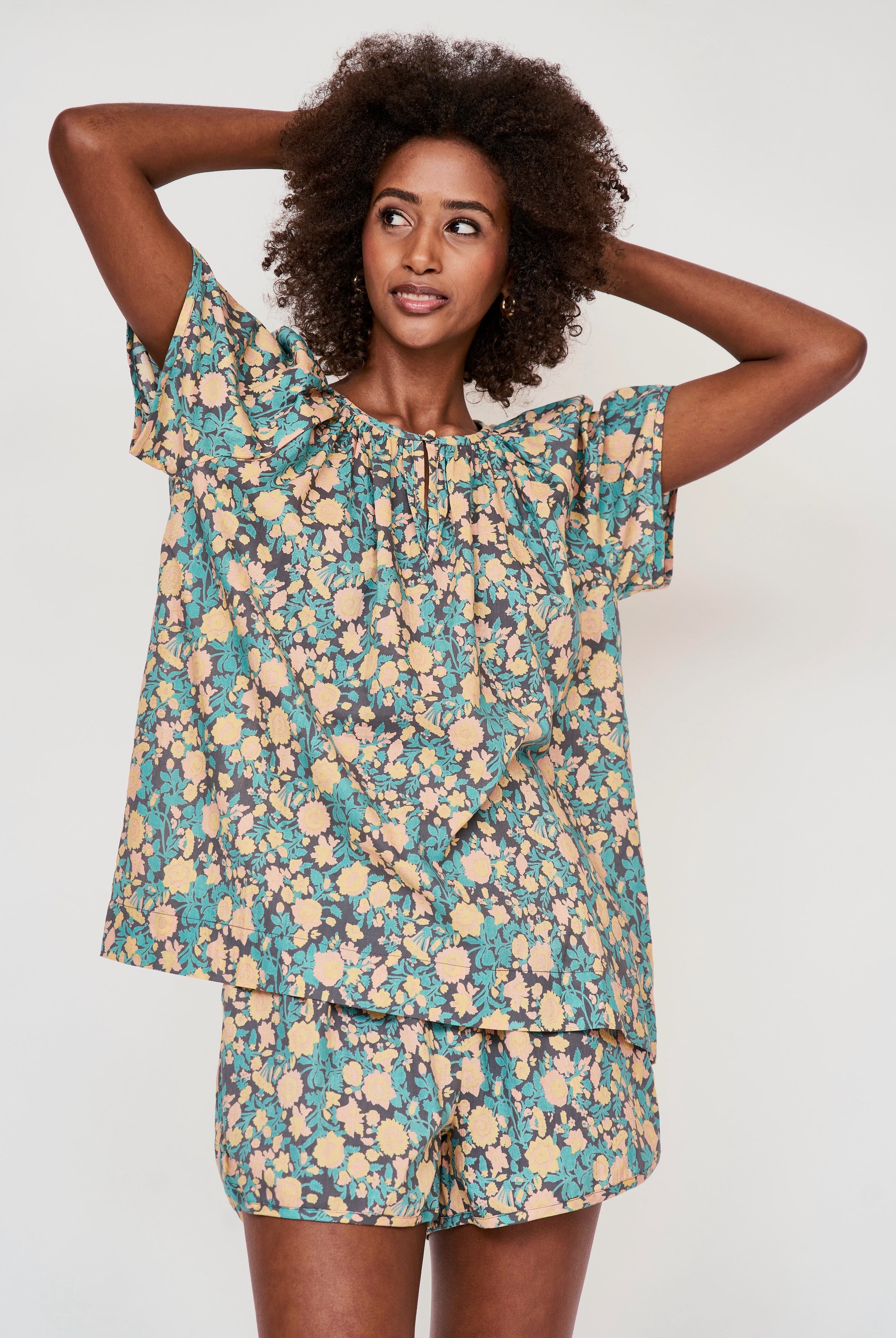 Girl wearing MIRTH women's short sleeve pajama short set in onyx bloom floral cotton