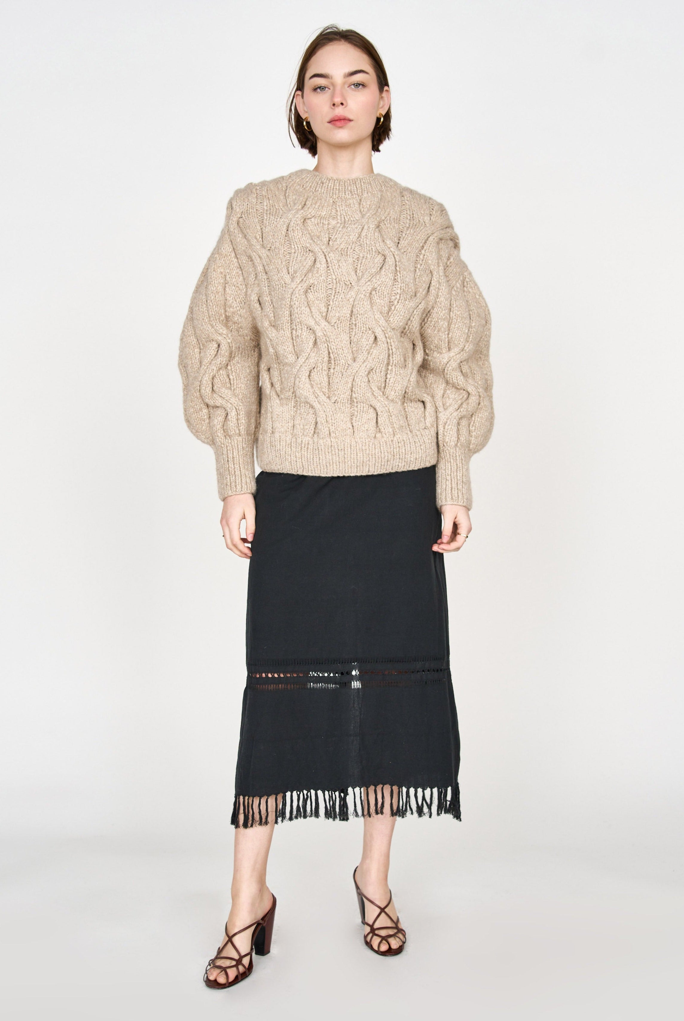 Girl wearing MIRTH women's handknit cortina cable pullover sweater in camel brown wool