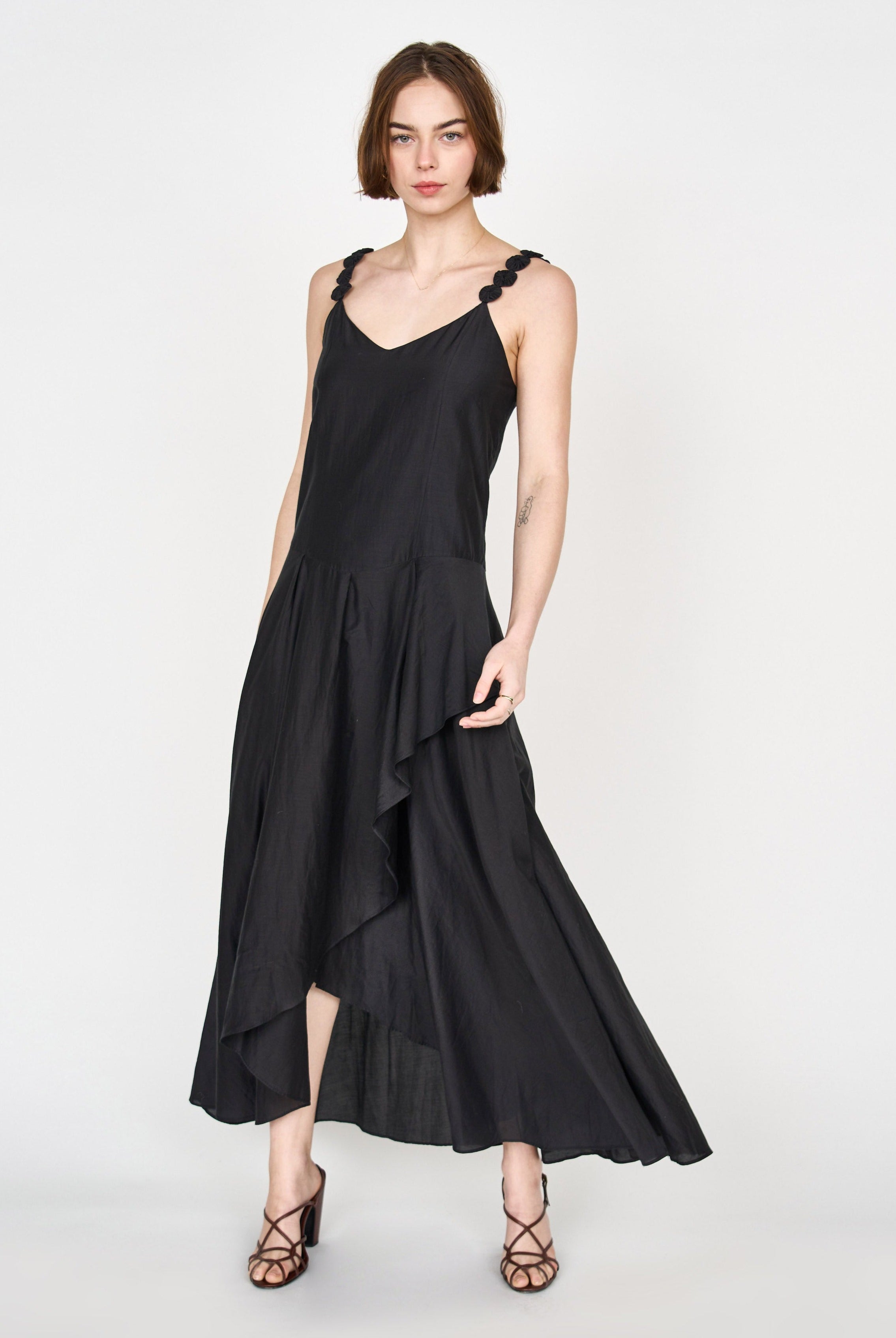 Girl wearing MIRTH women's long singapore spaghetti strap drop waist dress in black cotton silk