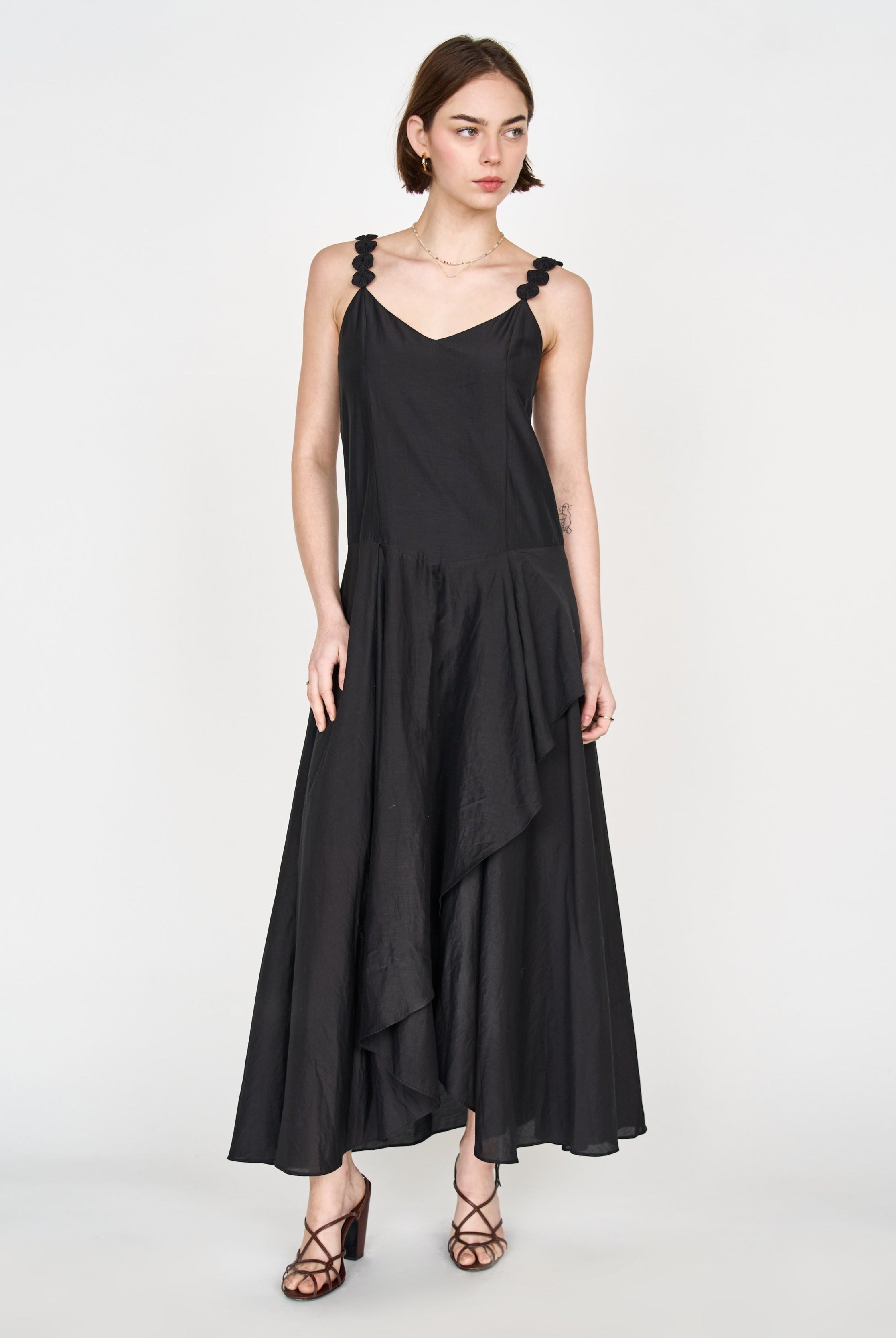 Girl wearing MIRTH women's long singapore spaghetti strap drop waist dress in black cotton silk