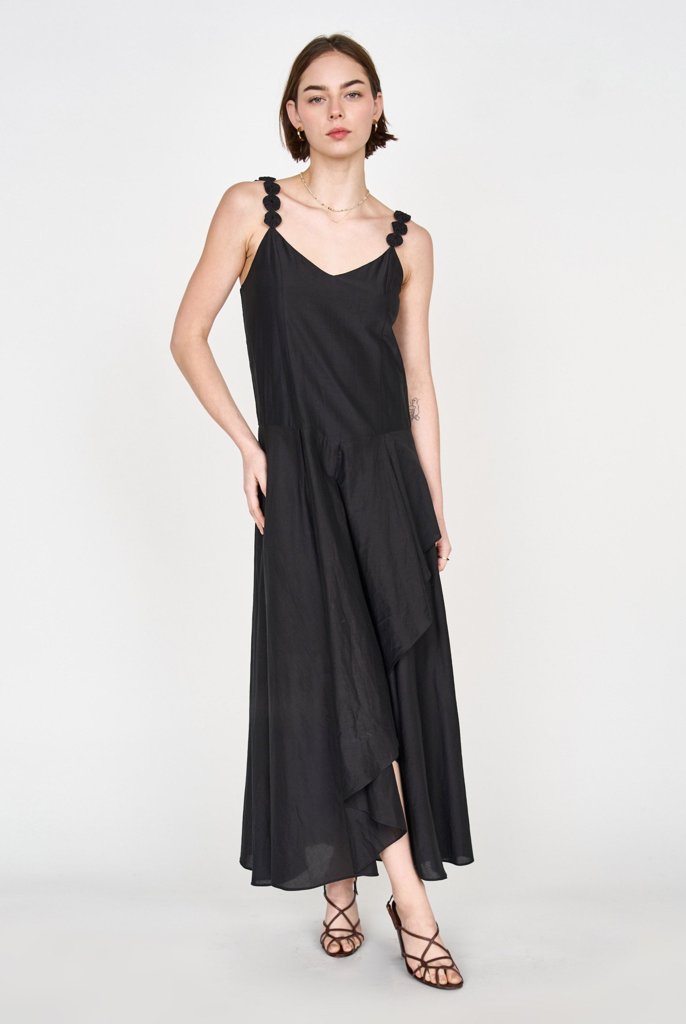 Girl wearing MIRTH women's long singapore spaghetti strap drop waist dress in black cotton silk