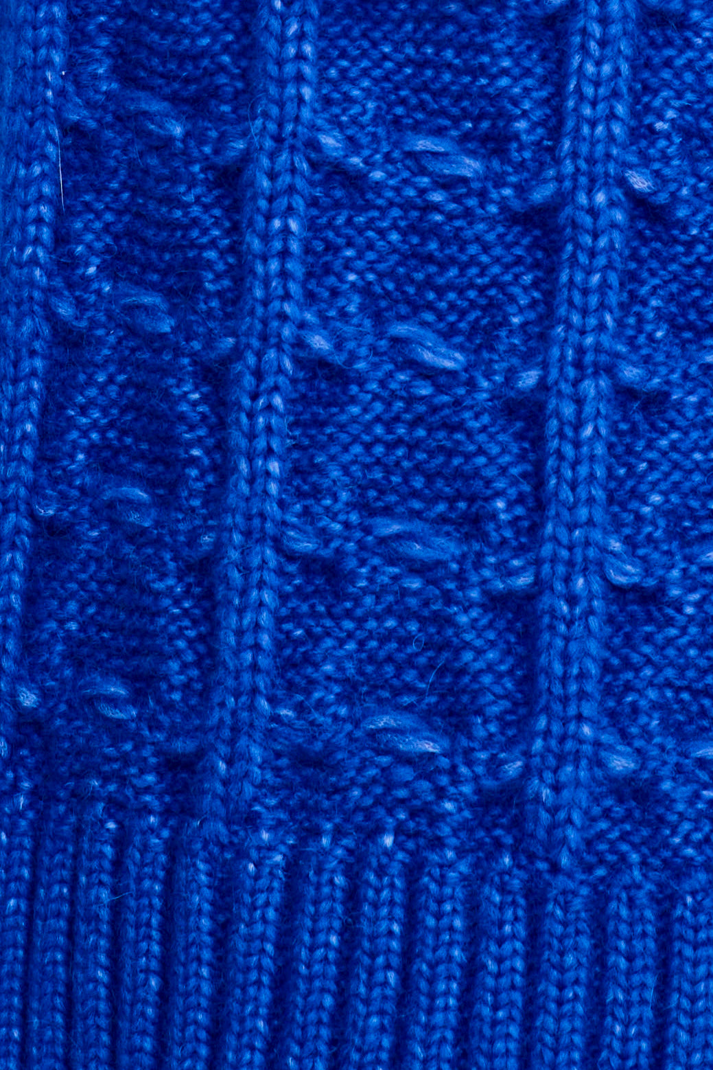 Close-up of a blue knitted fabric with intricate pattern