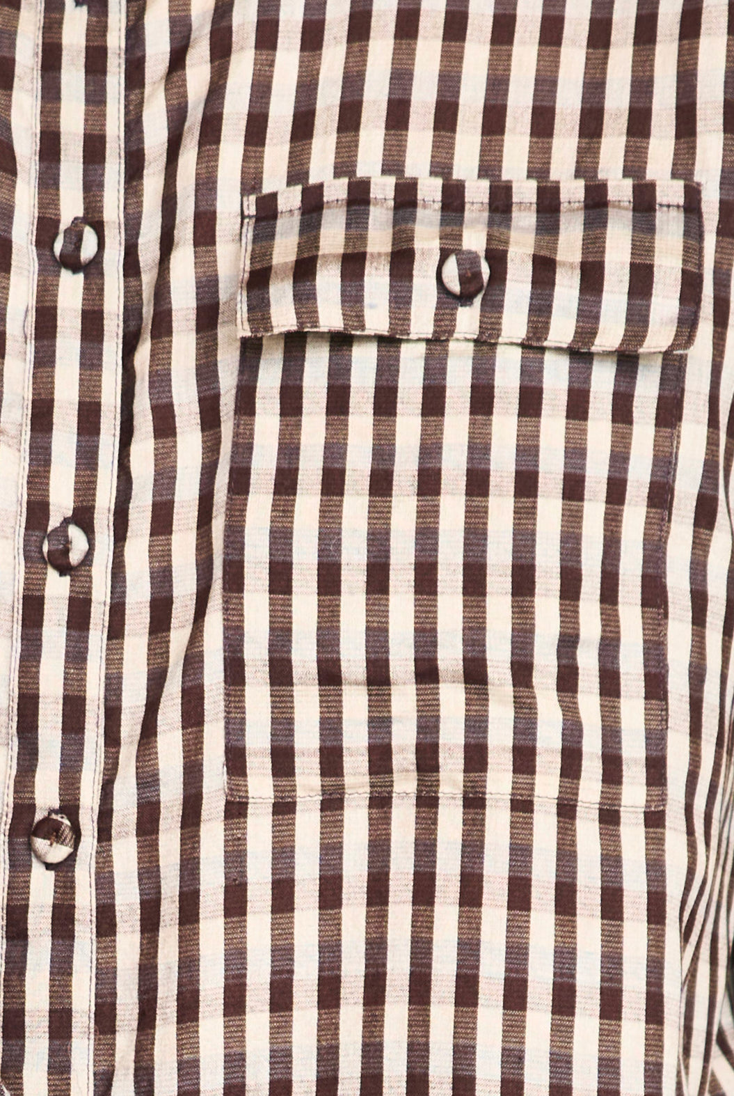 Close-up of a brown and white striped shirt with buttons.