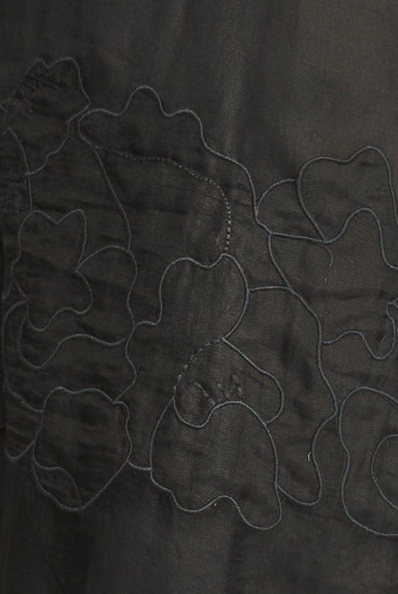 Close-up of dark fabric with embroidered floral patterns