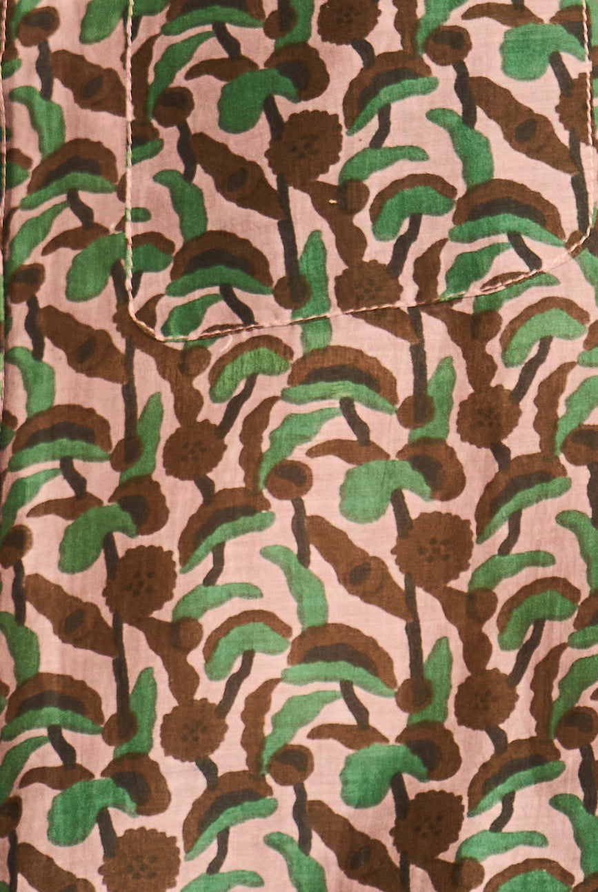 Patterned fabric with brown and green leaves on a beige background