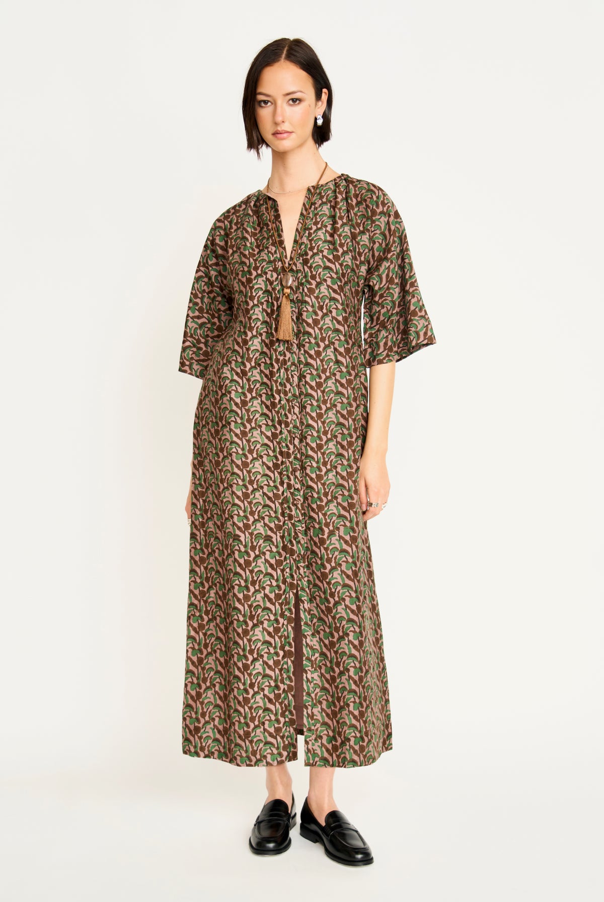Woman wearing a patterned dress on a white background