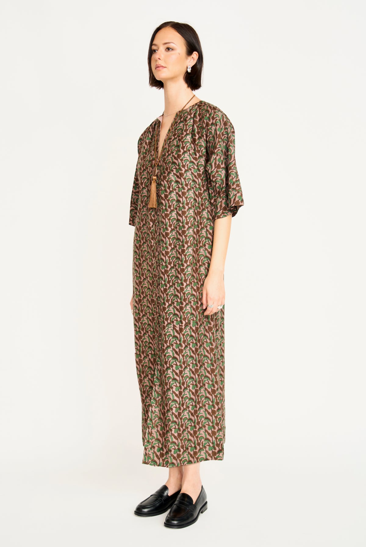 Woman wearing a patterned dress on a white background