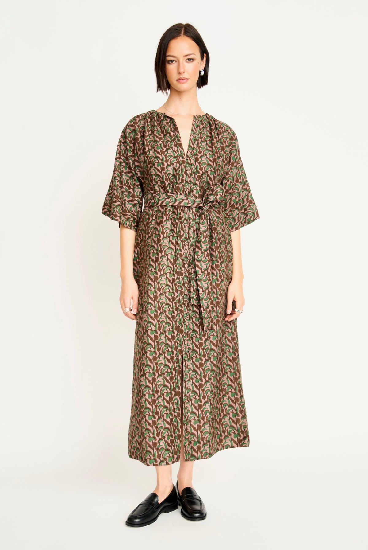 Woman wearing a patterned dress on a white background