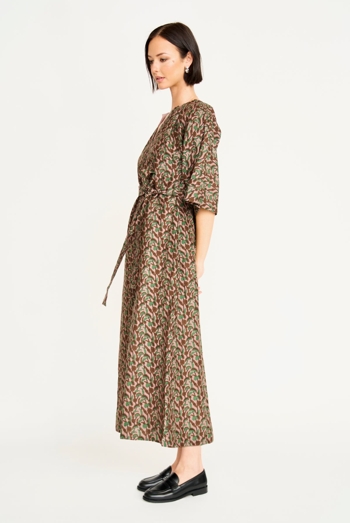 Woman wearing a patterned dress on a white background