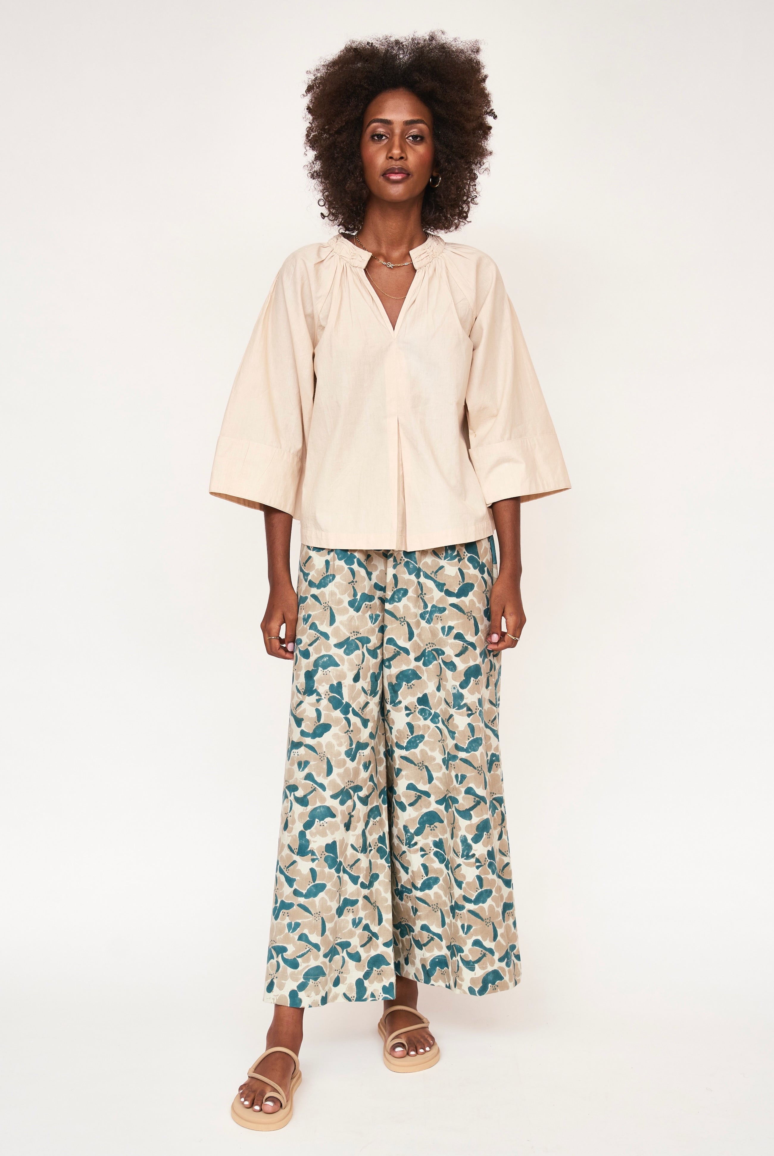 Girl wearing MIRTH women's v neck ruched collar three quarter sleeve palm springs top in parchment beige cotton poplin