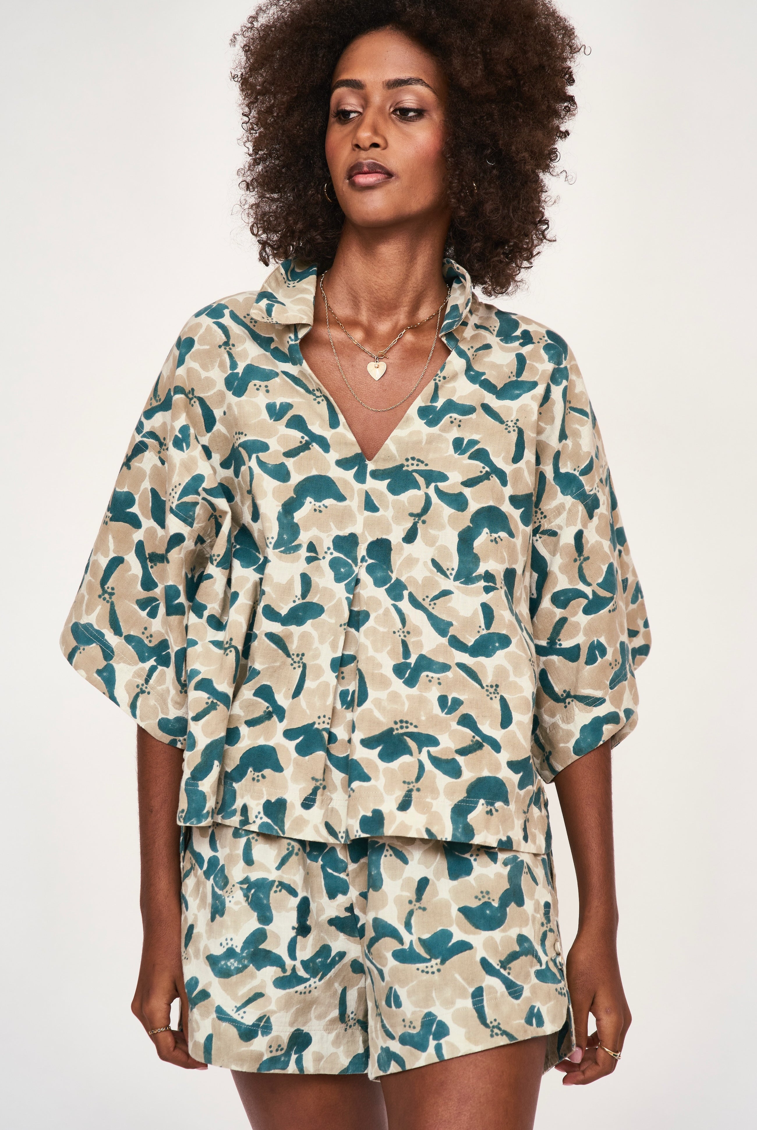 Girl wearing MIRTH women's wide leg elastic track shorts in plumeria blue floral print cotton