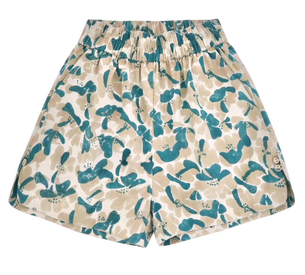 Girl wearing MIRTH women's wide leg elastic track shorts in plumeria blue floral print cotton