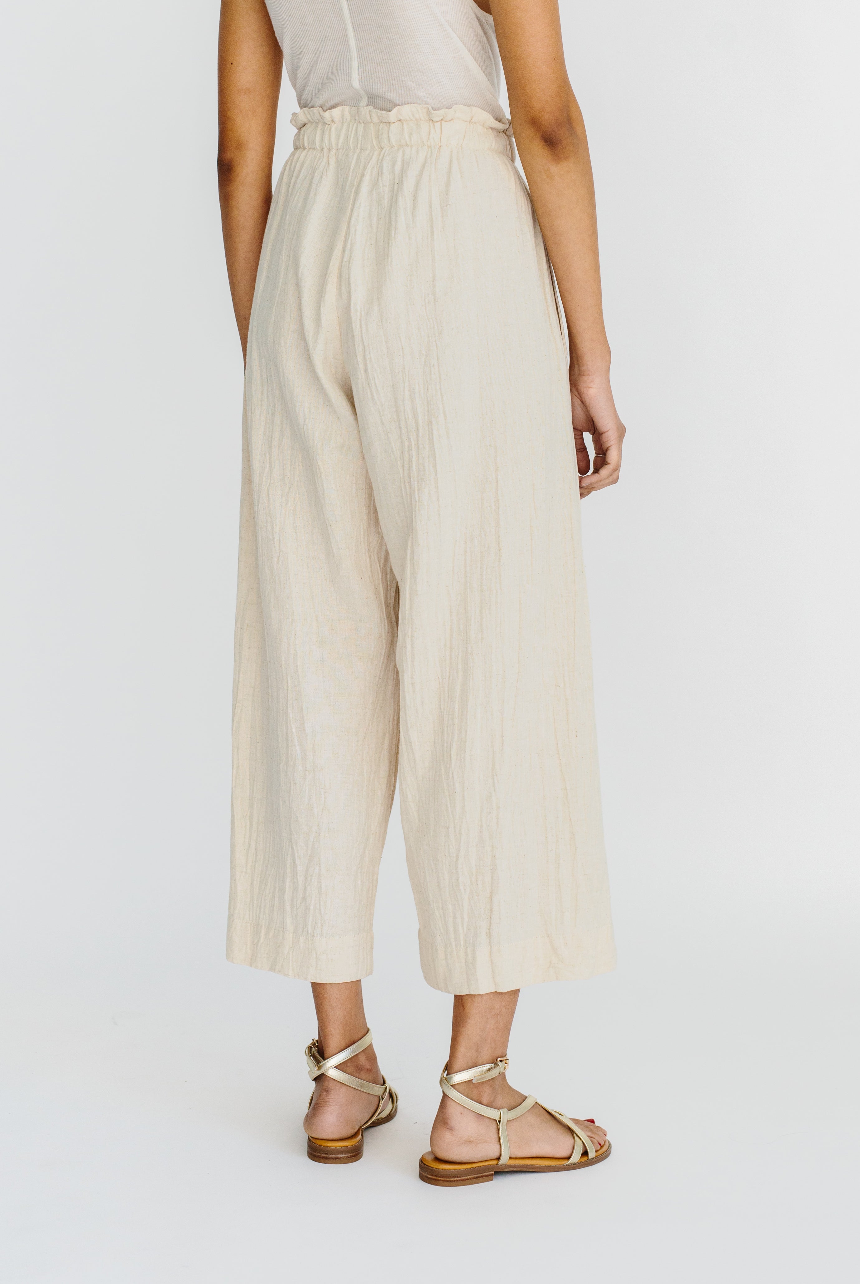 Girl wearing MIRTH women's paperbag waist wide leg palazzo pant in oatmeal beige