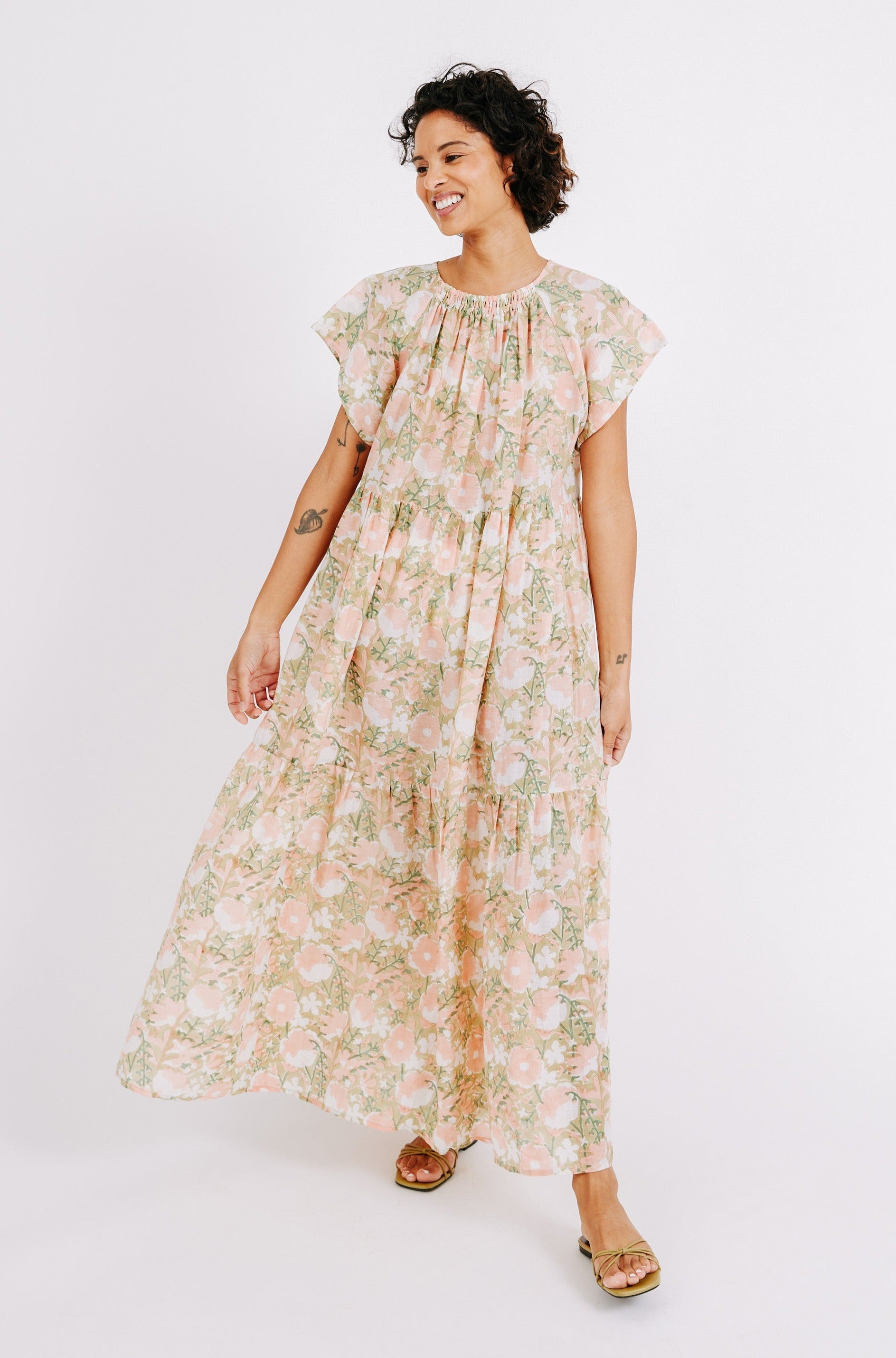 Girl wearing MIRTH women's long tiered short sleeve vienna maxi dress in snapdragon bloom pink floral print cotton