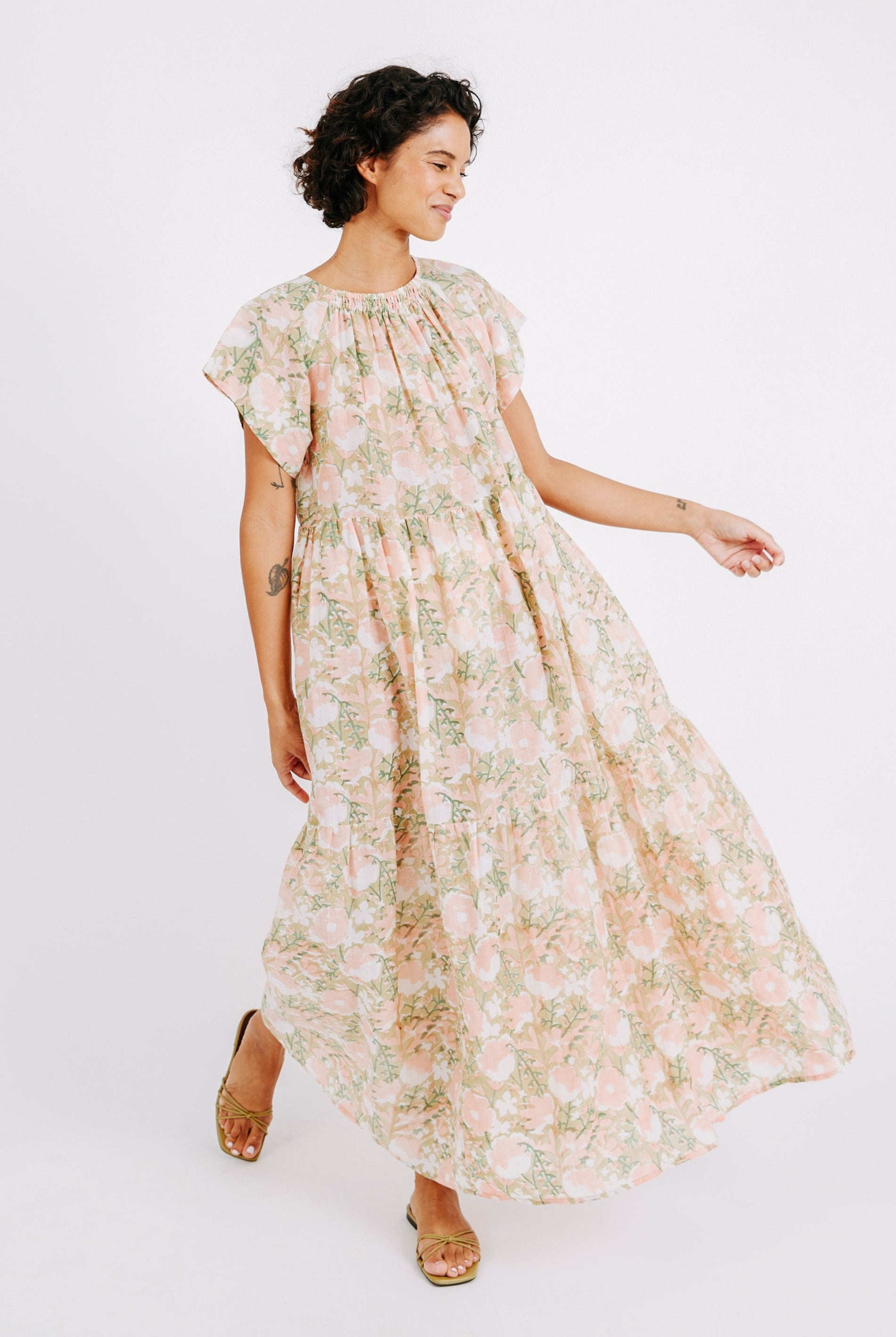 Girl wearing MIRTH women's long tiered short sleeve vienna maxi dress in snapdragon bloom pink floral print cotton