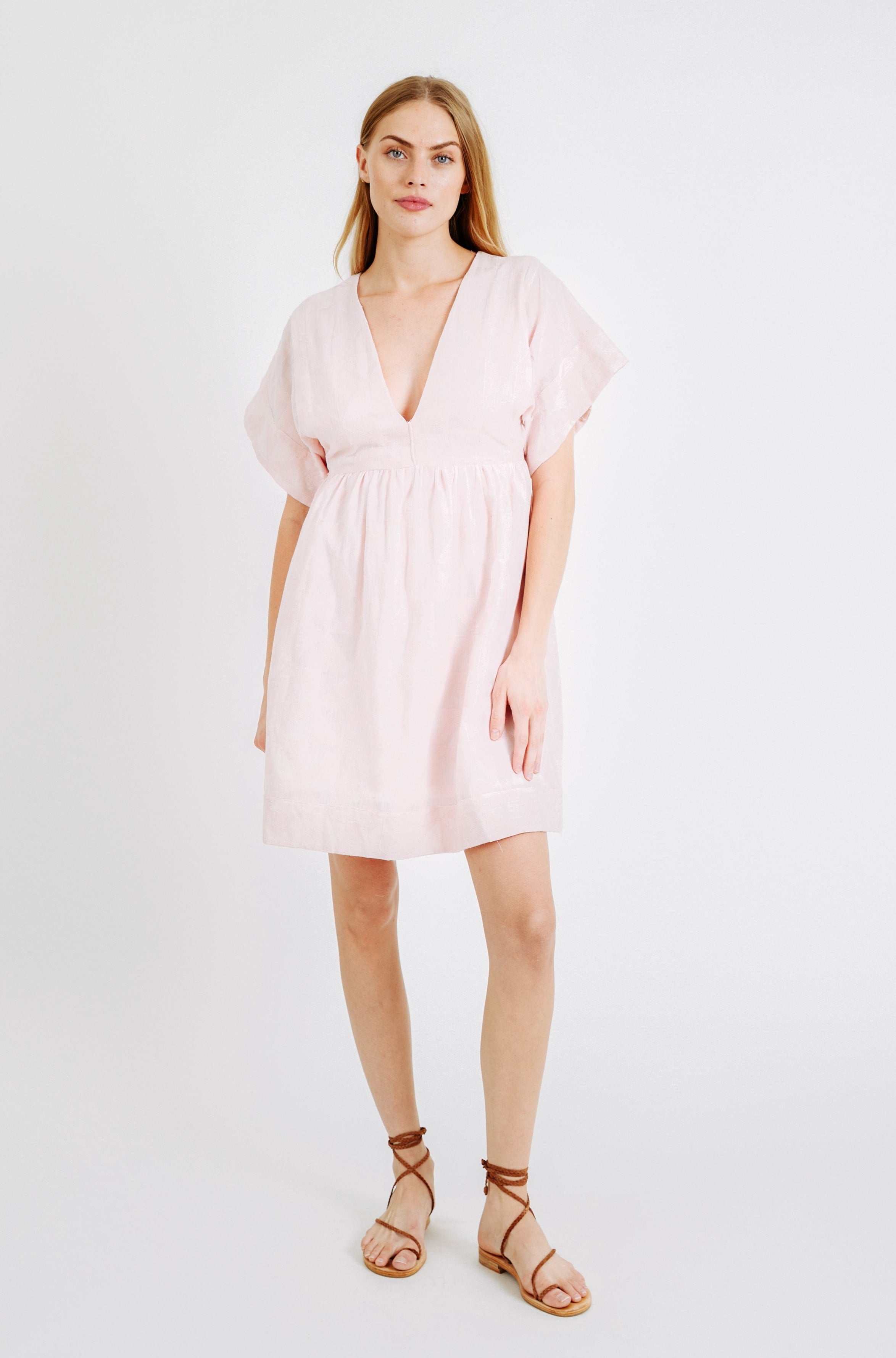 Girl wearing MIRTH women's v-neck short sonoma dress in handloomed light pink rosa cotton jacquard