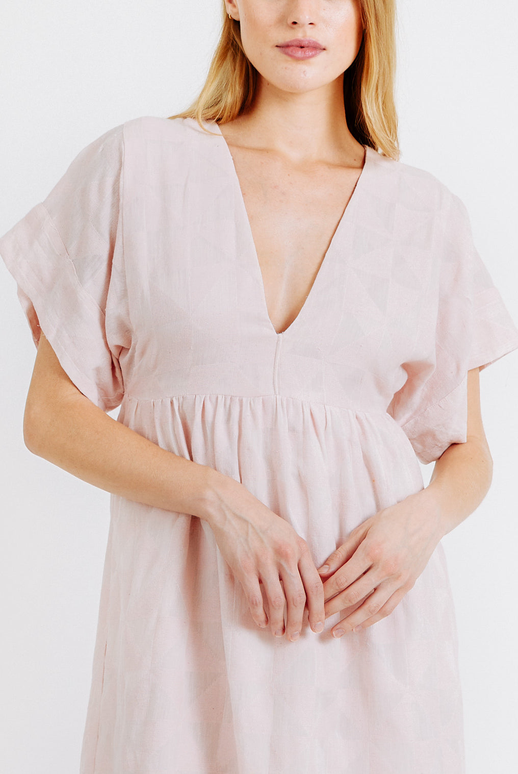 Girl wearing MIRTH women's v-neck short sonoma dress in handloomed light pink rosa cotton jacquard