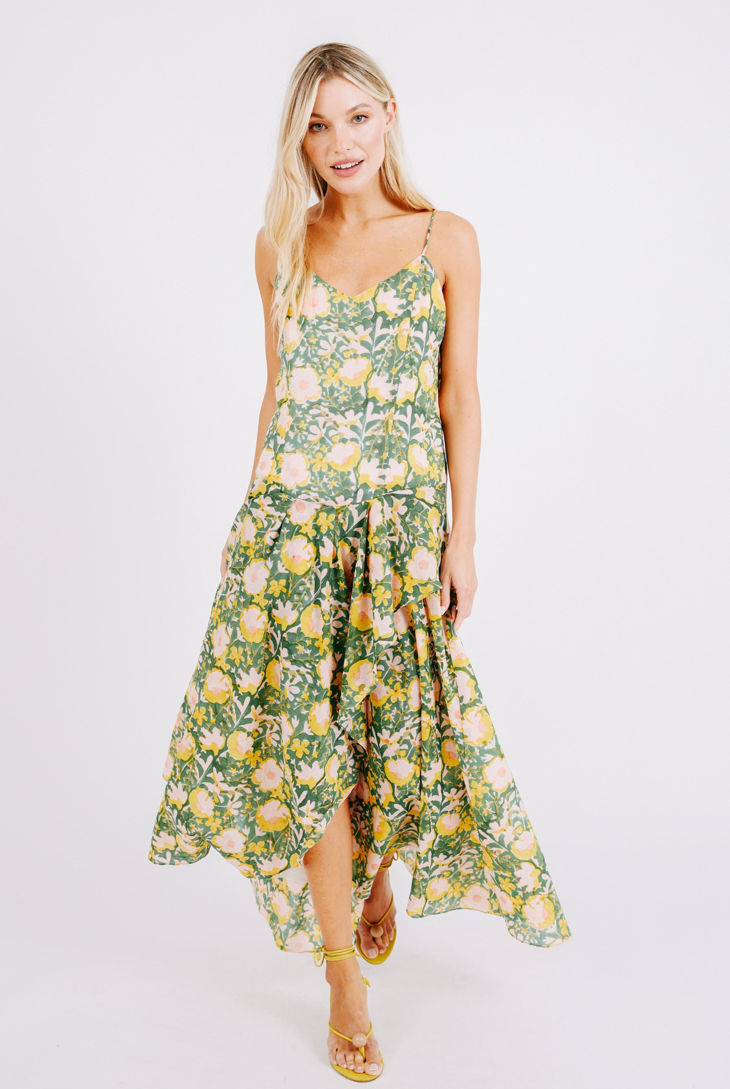Girl wearing MIRTH women's long singapore spaghetti strap drop waist dress in camelia bloom green floral print cotton