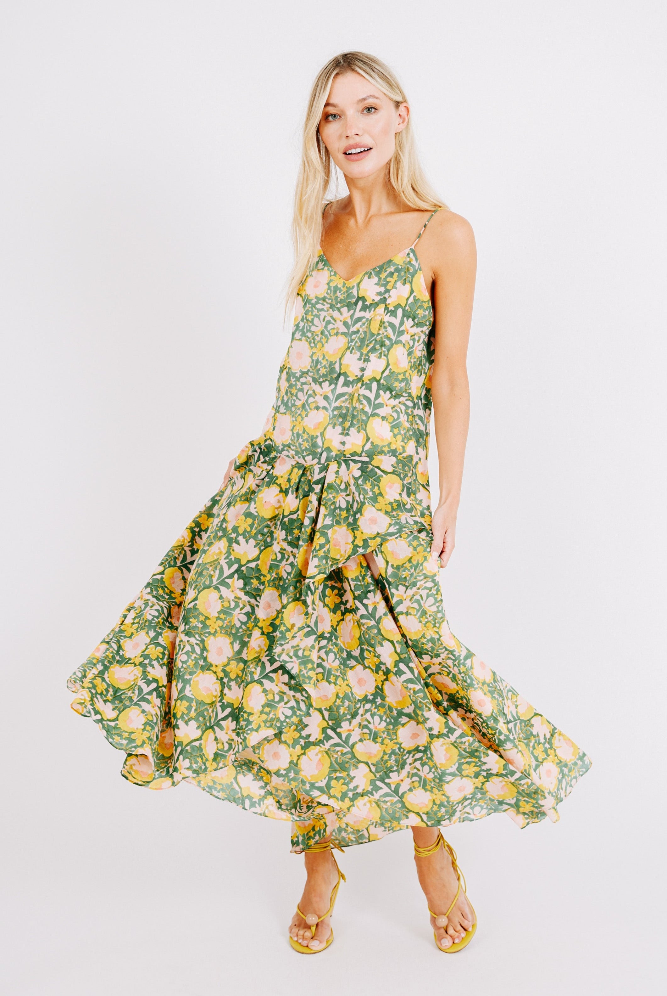 Girl wearing MIRTH women's long singapore spaghetti strap drop waist dress in camelia bloom green floral print cotton