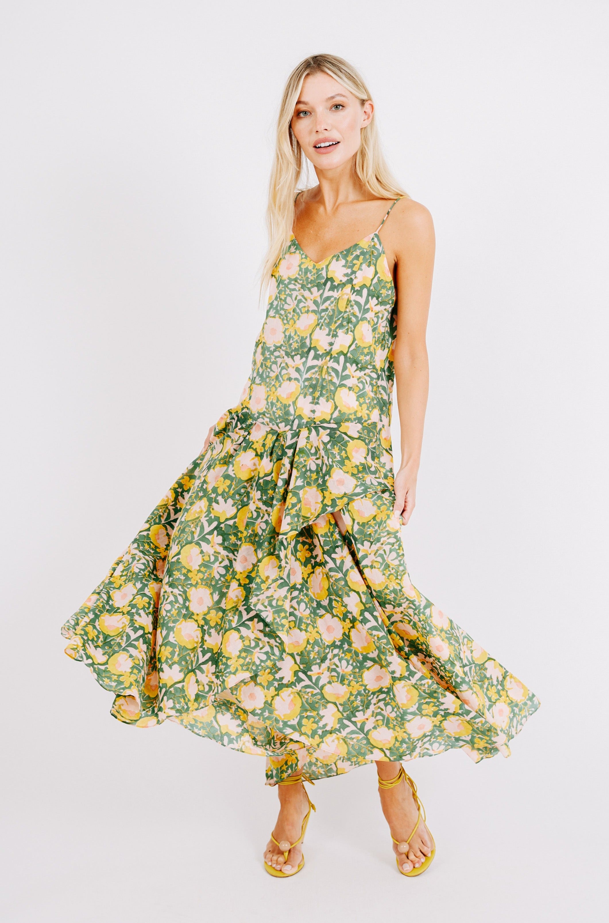 Girl wearing MIRTH women's long singapore spaghetti strap drop waist dress in camelia bloom green floral print cotton