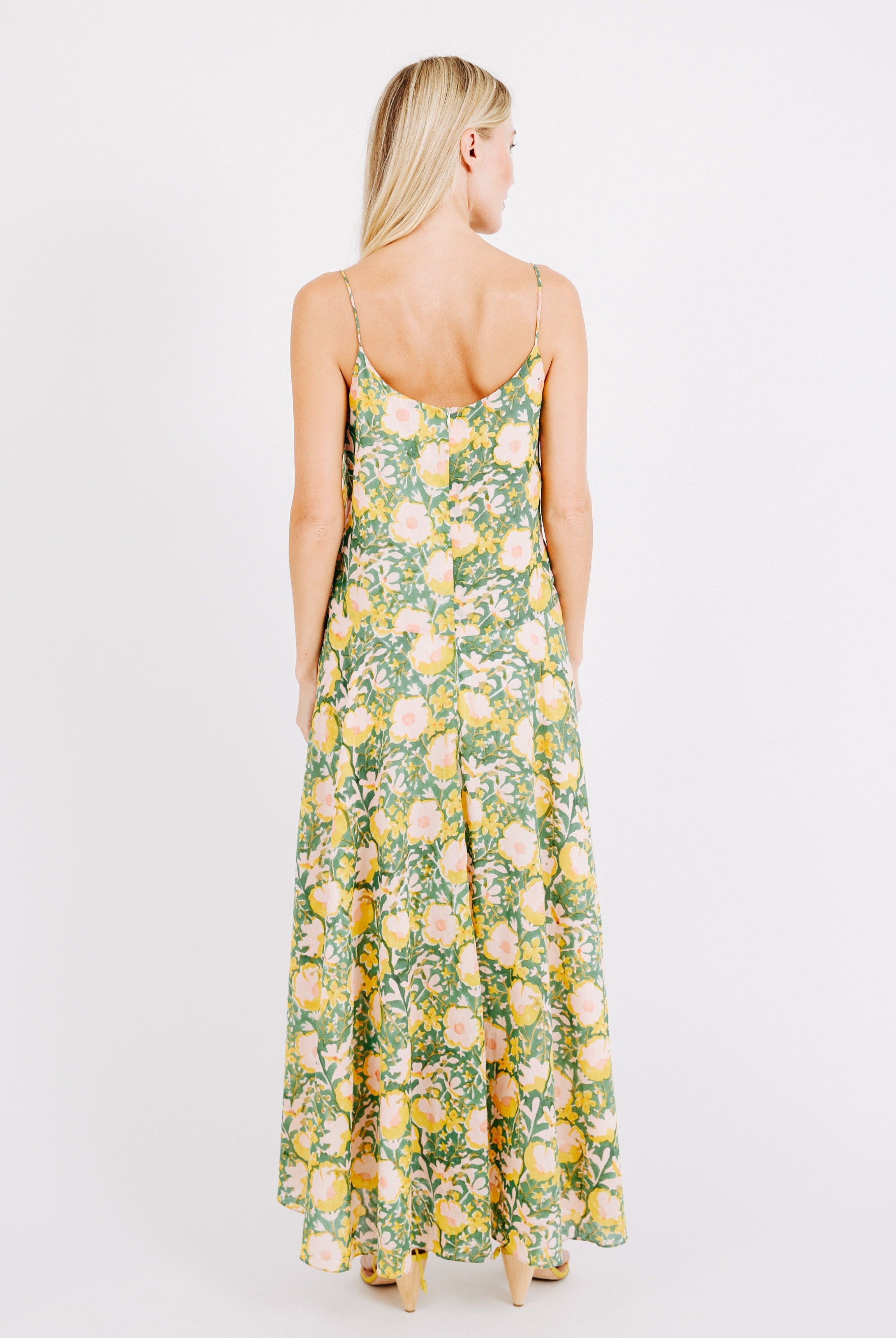 Girl wearing MIRTH women's long singapore spaghetti strap drop waist dress in camelia bloom green floral print cotton