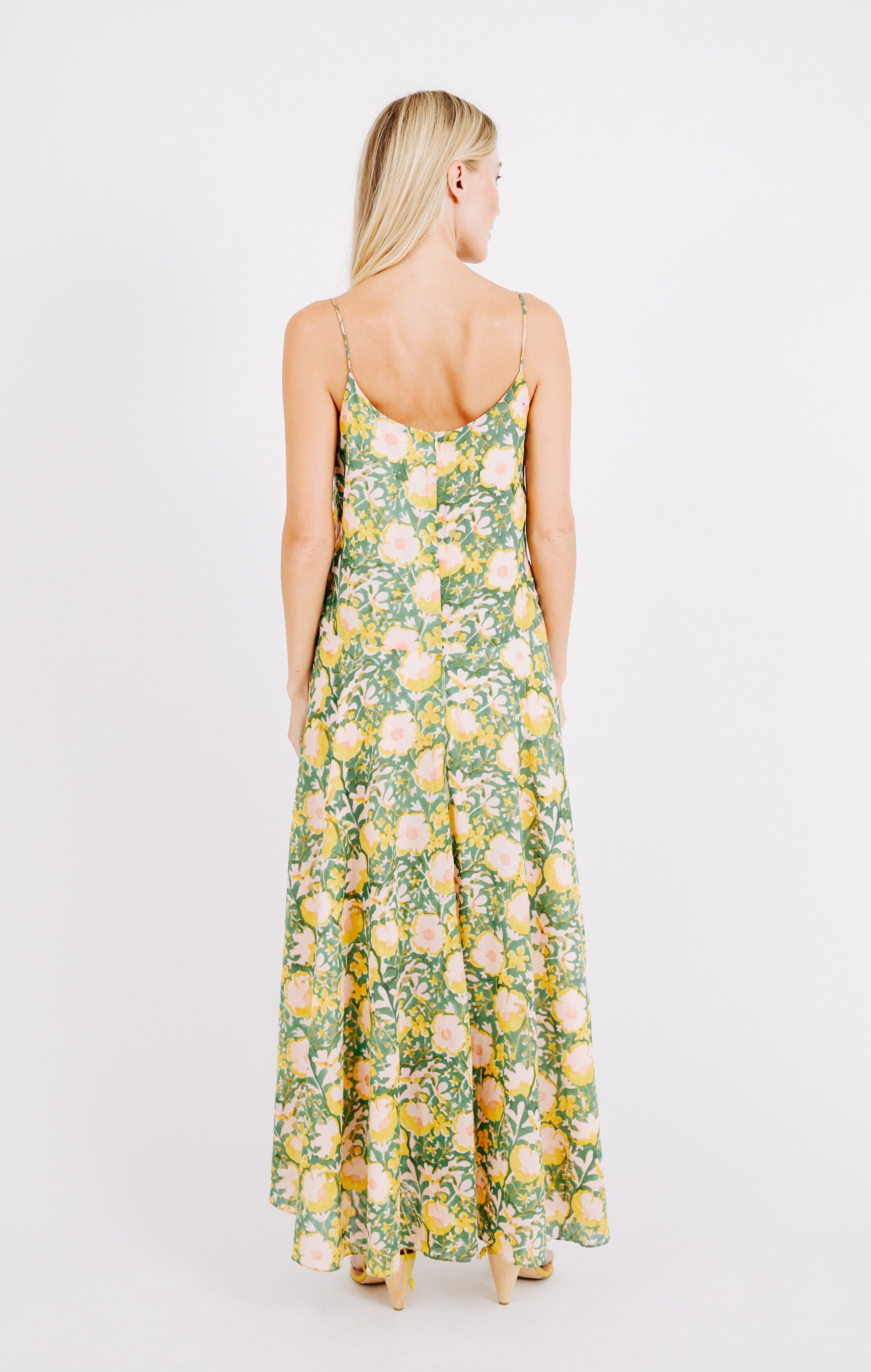 Girl wearing MIRTH women's long singapore spaghetti strap drop waist dress in camelia bloom green floral print cotton