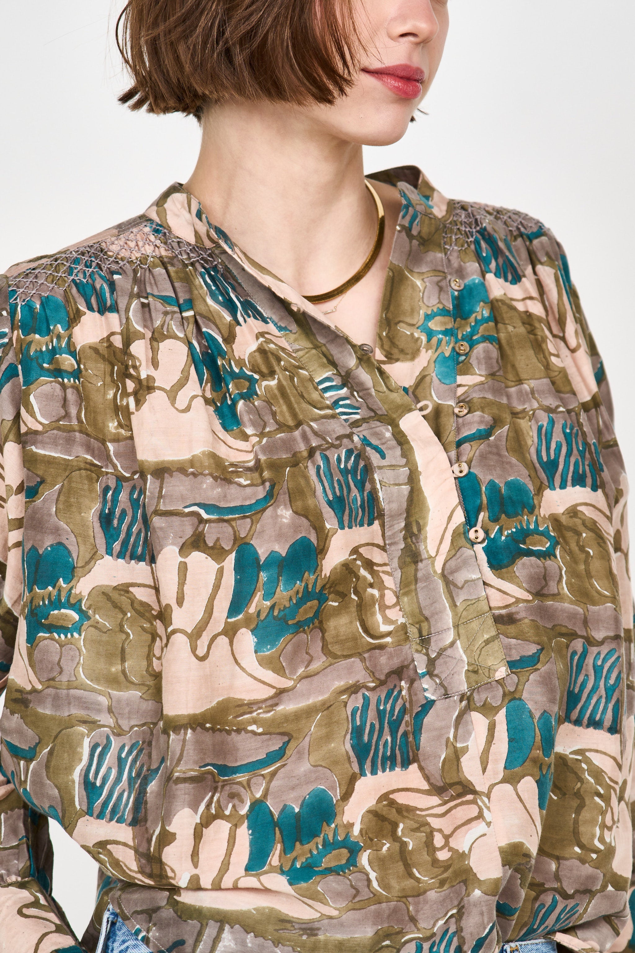 Girl wearing MIRTH women's button up smocked lightweight florence blouse in brown moss reef print cotton