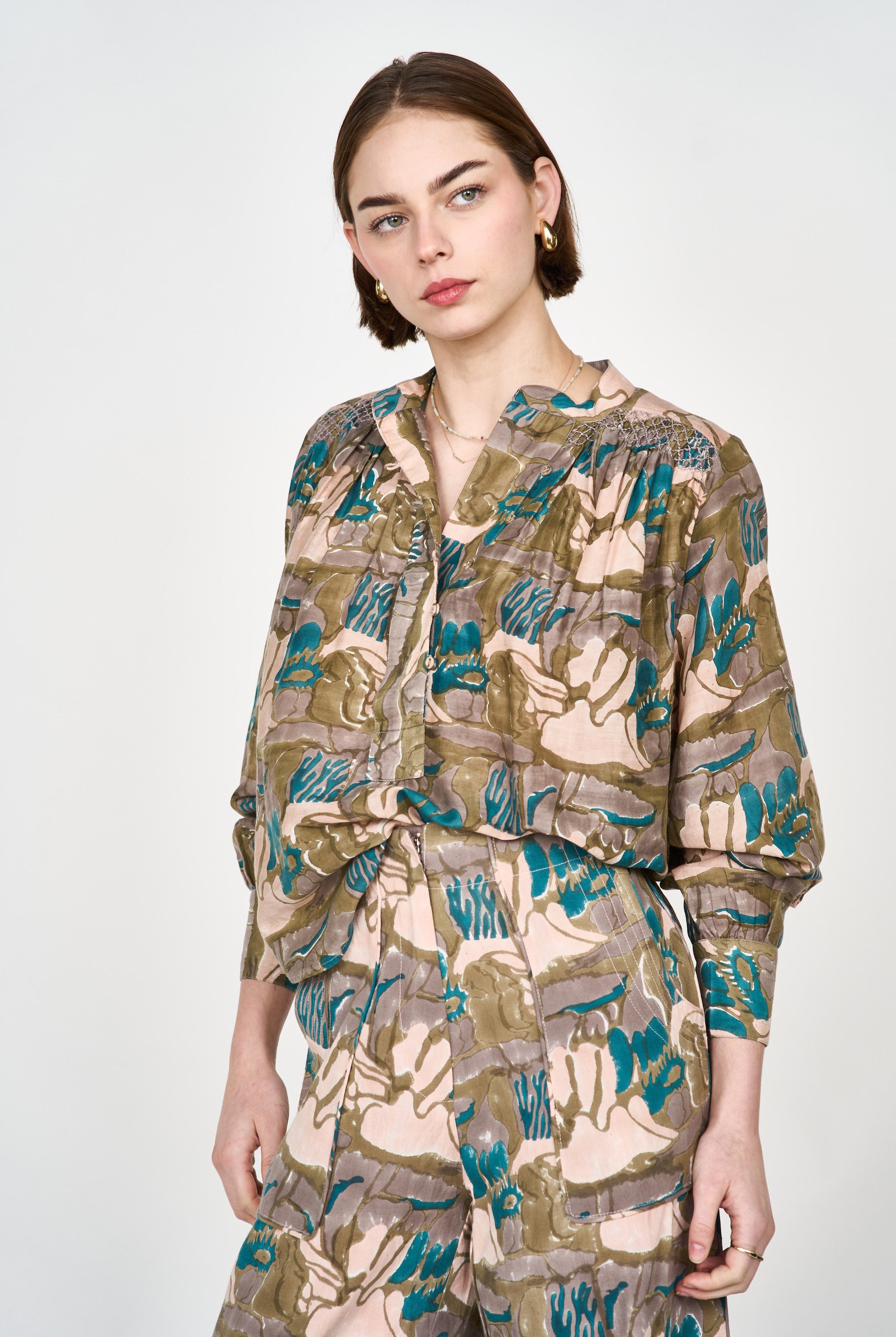 Girl wearing MIRTH women's button up smocked lightweight florence blouse in brown moss reef print cotton