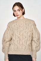 Girl wearing MIRTH women's handknit cortina cable pullover sweater in camel brown wool