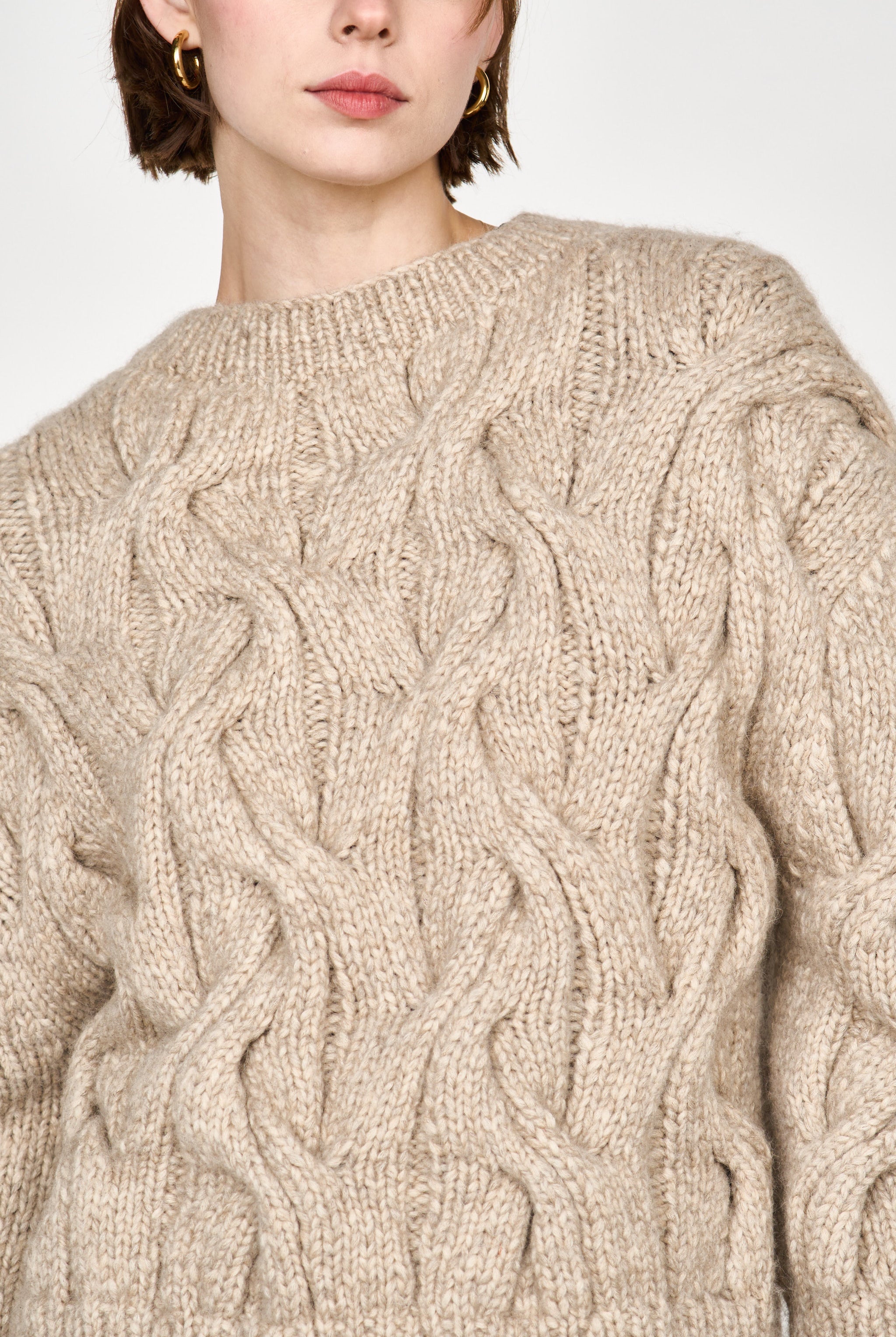 Girl wearing MIRTH women's handknit cortina cable pullover sweater in camel brown wool