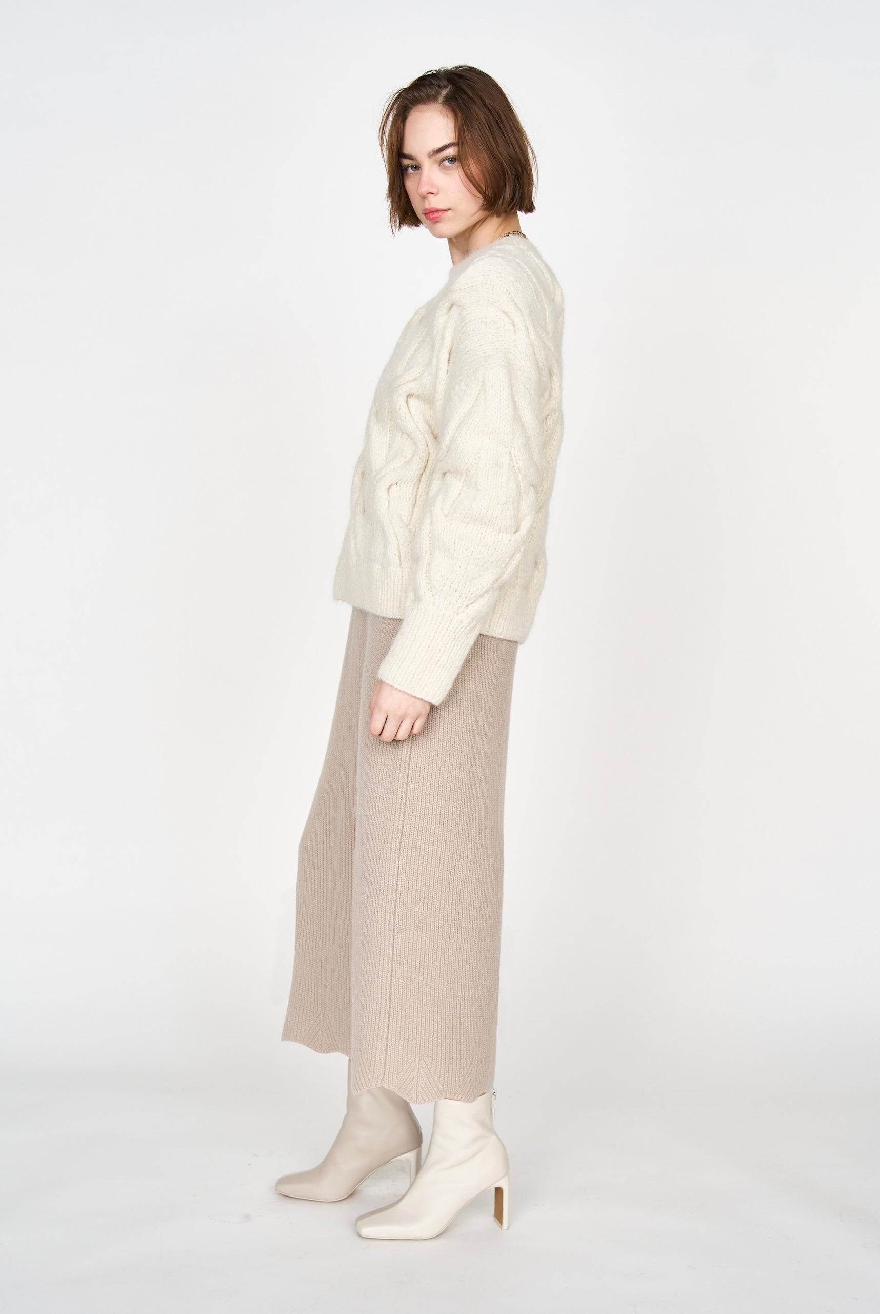 Girl wearing MIRTH women's handknit cortina cable pullover sweater in cream white wool