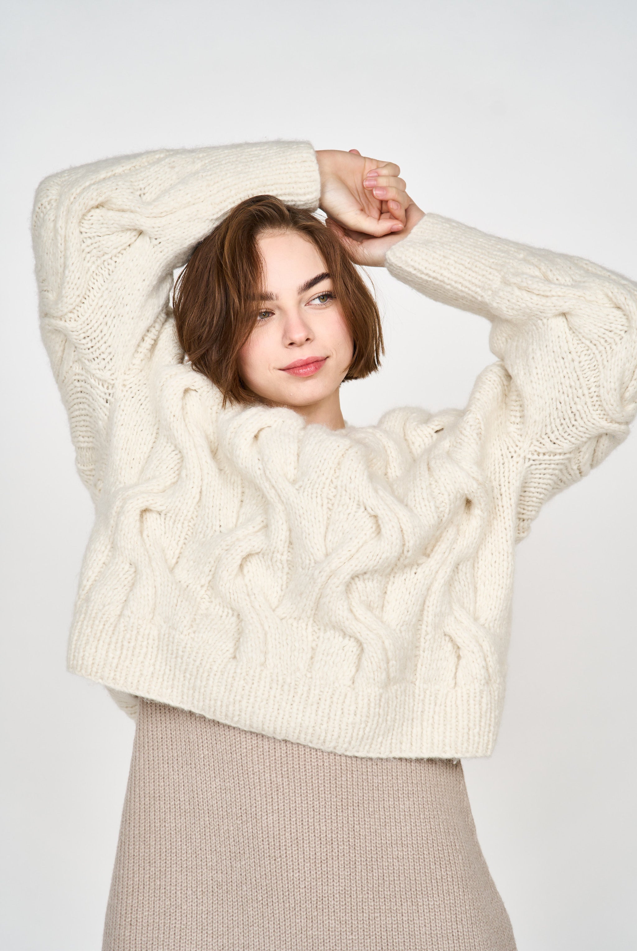 Girl wearing MIRTH women's handknit cortina cable pullover sweater in cream white wool