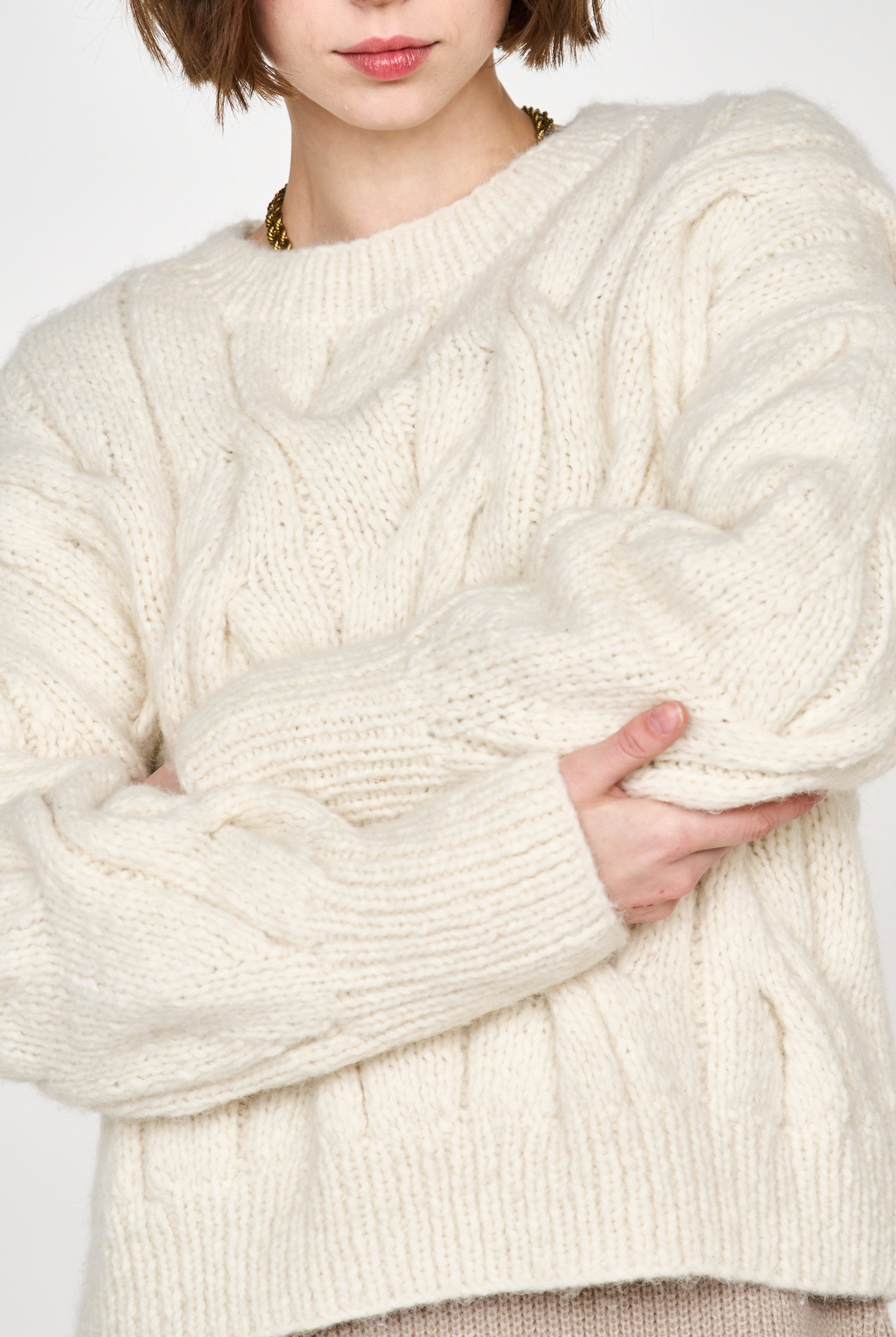 Girl wearing MIRTH women's handknit cortina cable pullover sweater in cream white wool