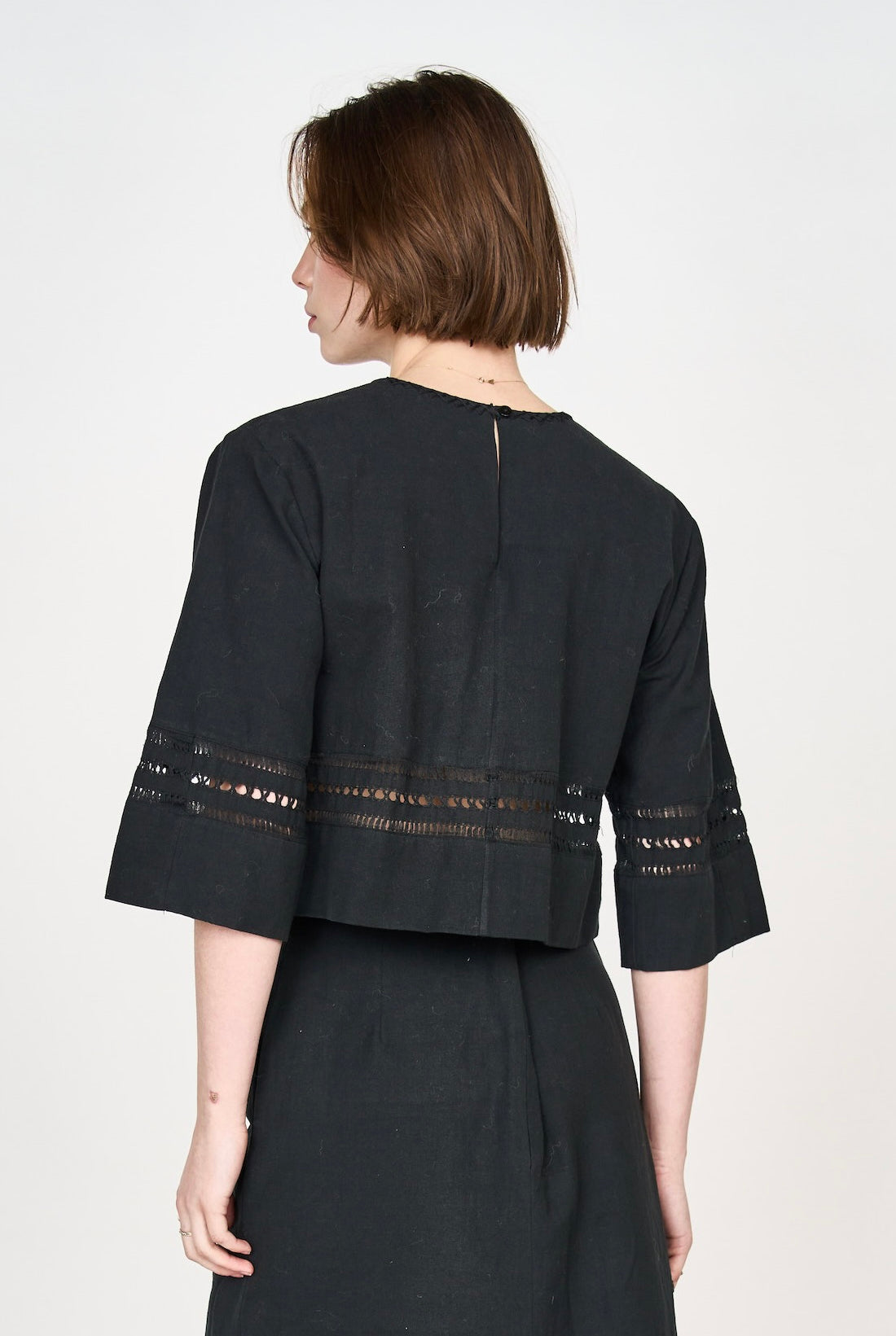 Girl wearing MIRTH women's fringe cutout quarter sleeve sintra top in black cotton