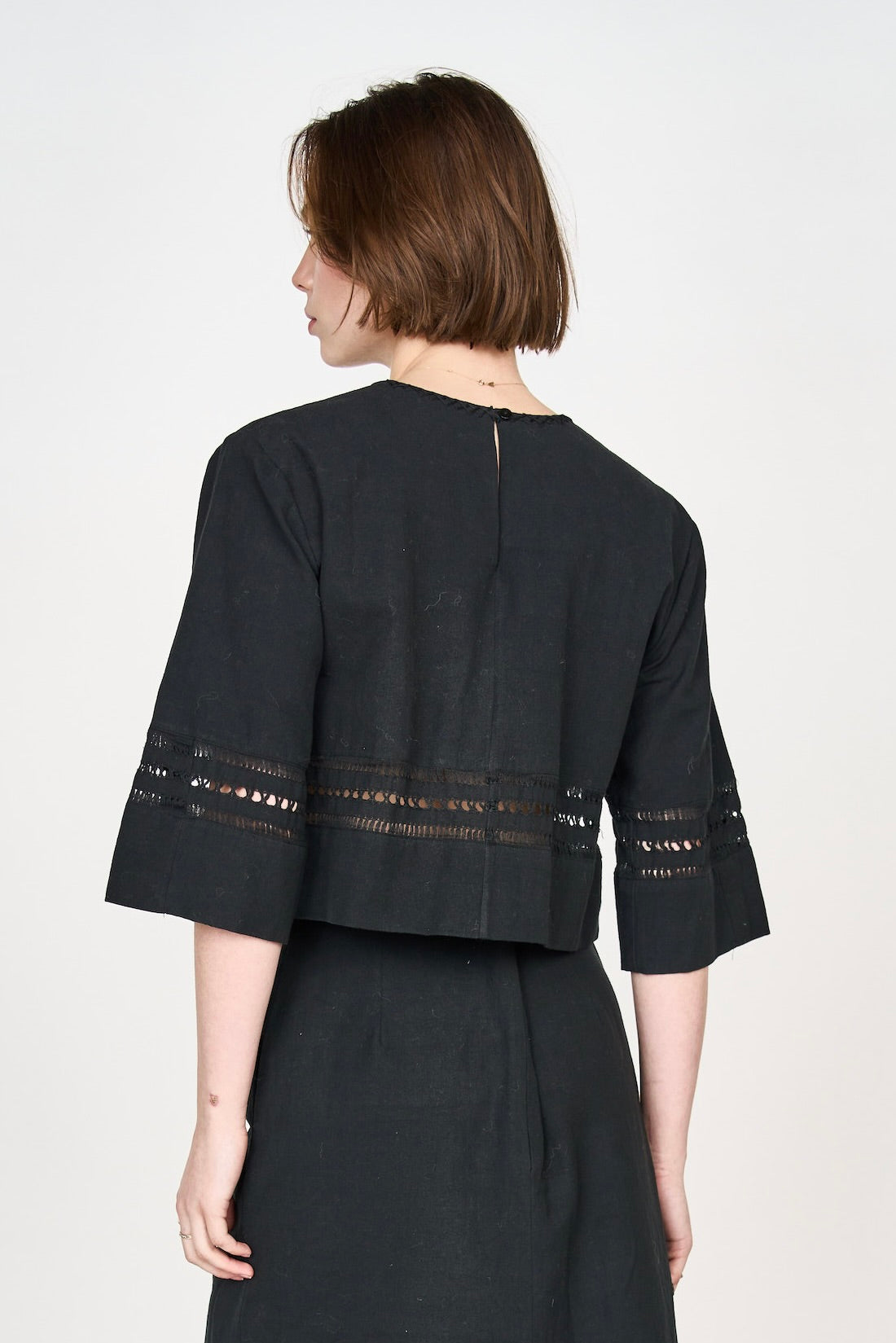 Girl wearing MIRTH women's fringe cutout quarter sleeve sintra top in black cotton