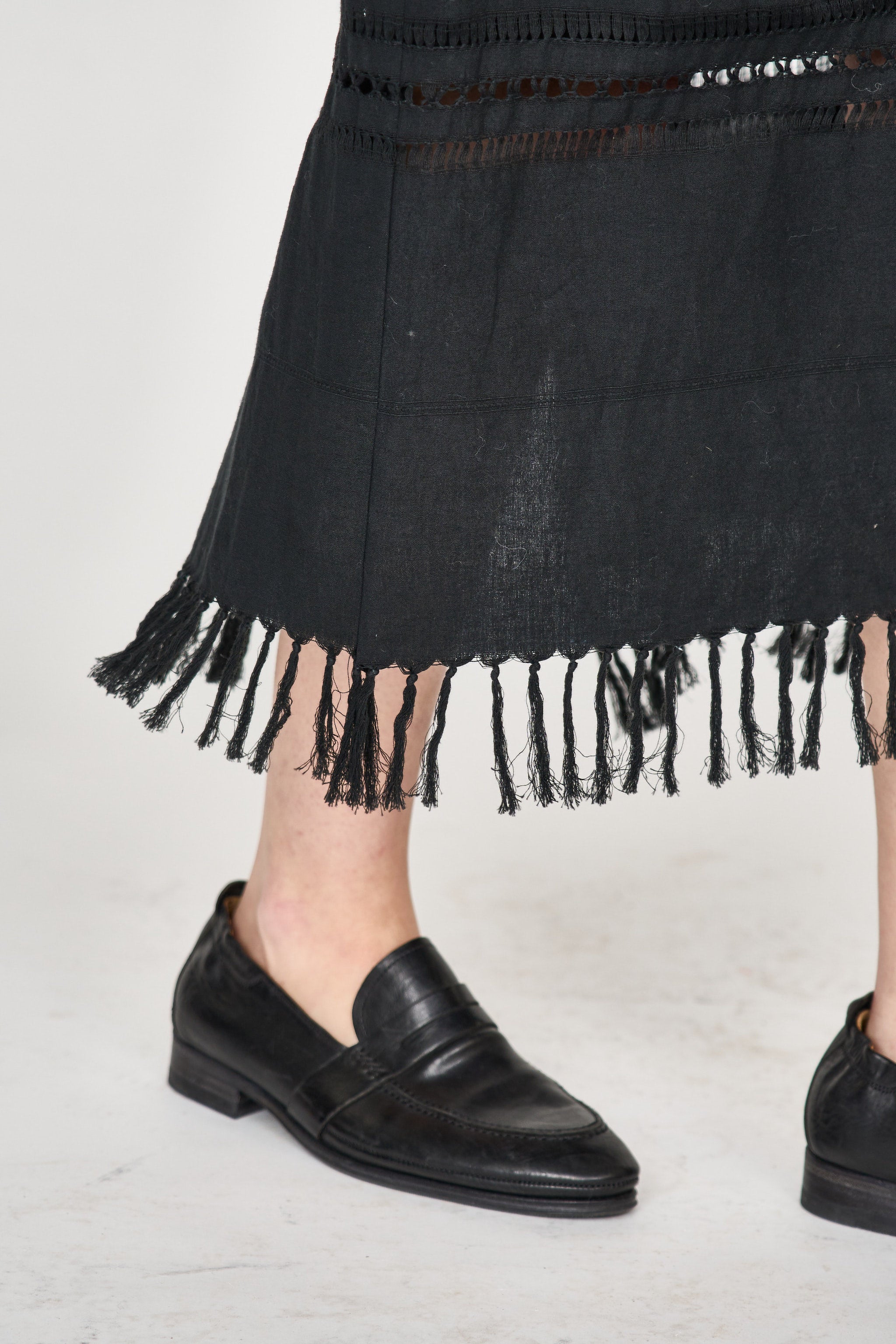 Girl wearing MIRTH women's midi fringe cutout lombok skirt in black cotton