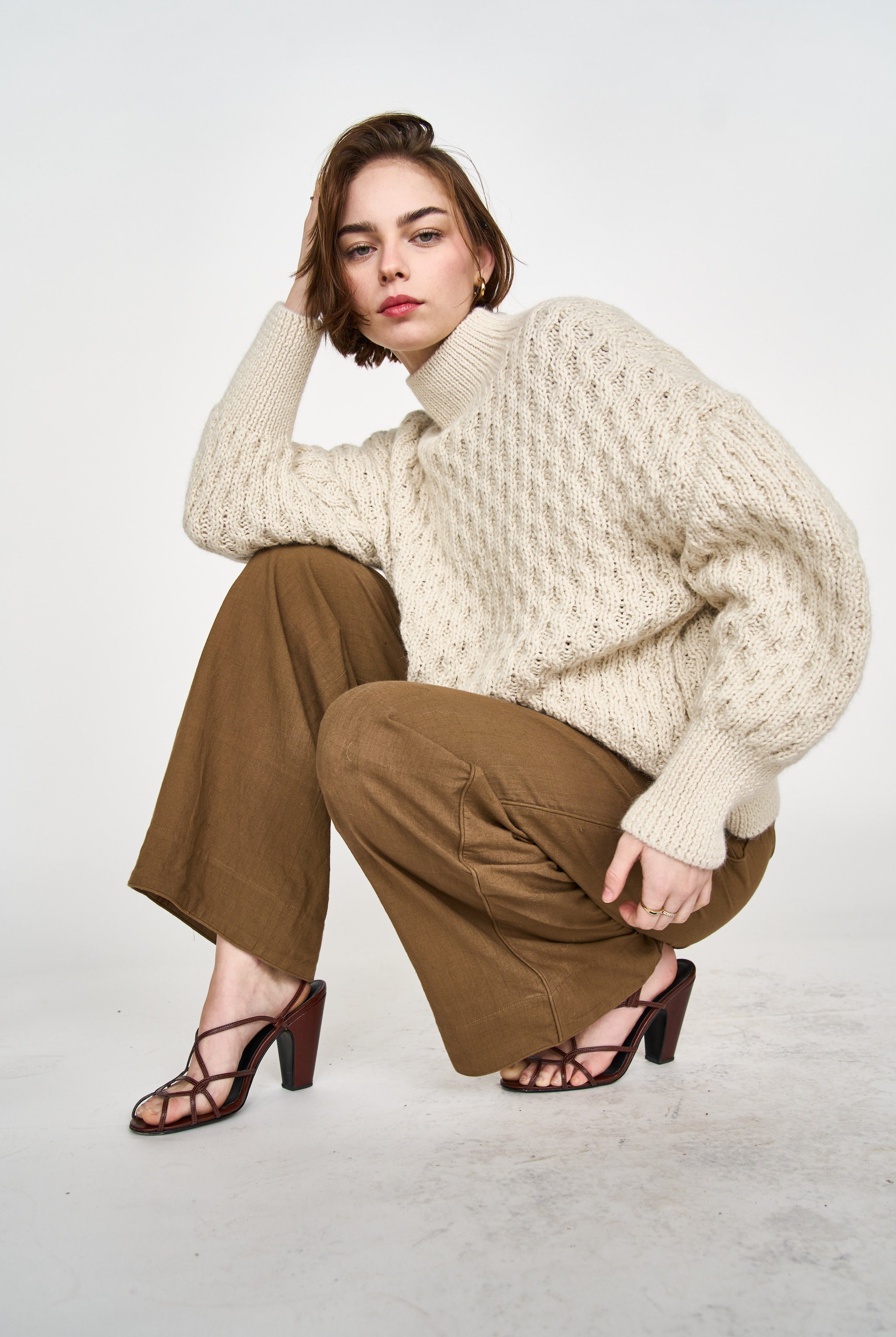 Girl wearing MIRTH women's pullover hand knit honeycomb weave megeve turtleneck sweater in ivory alpaca wool