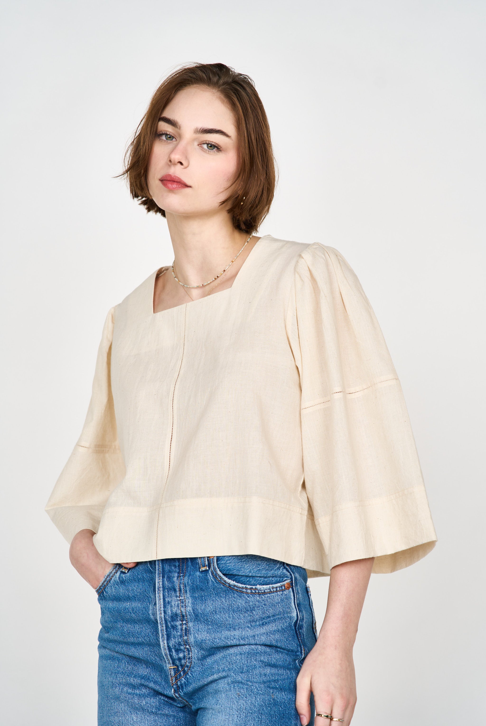 Girl wearing MIRTH women's pullover square neck cropped provence top in cream ecru cotton