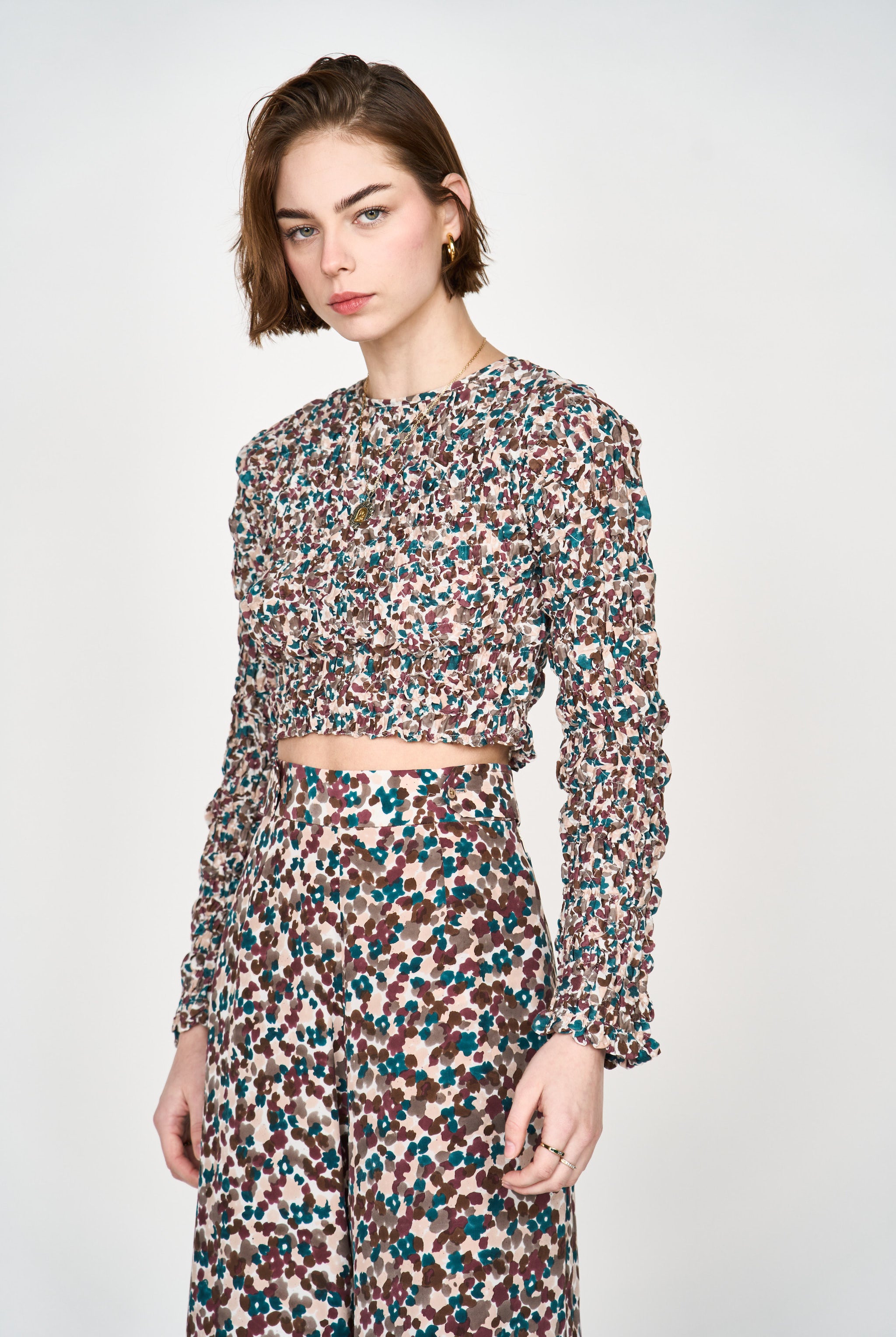 Girl wearing MIRTH women's long sleeve smocked elastic shoreditch top in purple red amaryllis print