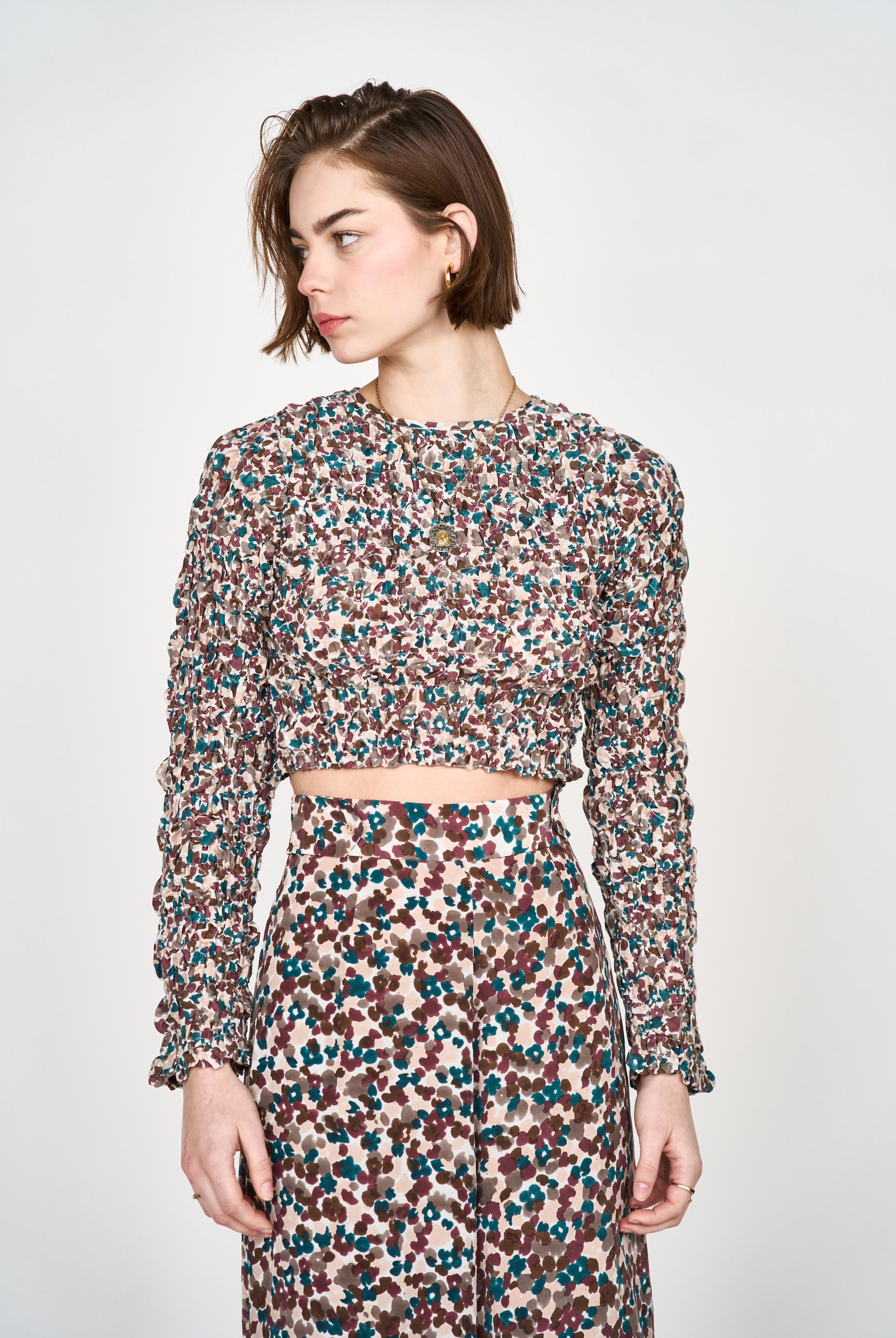 Girl wearing MIRTH women's long sleeve smocked elastic shoreditch top in purple red amaryllis print